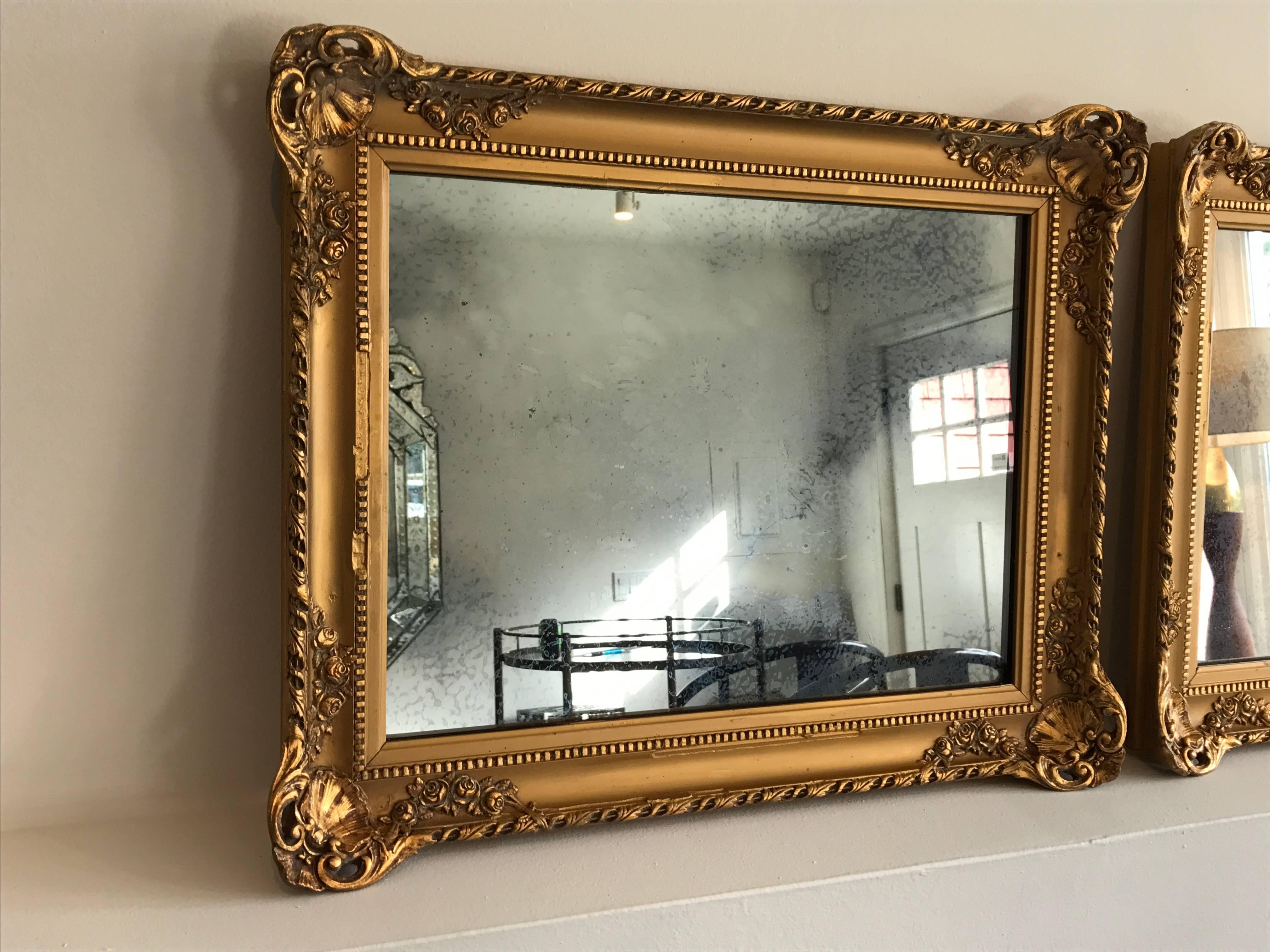 Very elegant pair of Baroque gold gilt plaster and wood framed mirrors. Smokey antiqued mirror. Can be presented horizontally or vertically. Minor loss, please see photos, professionally touched up.