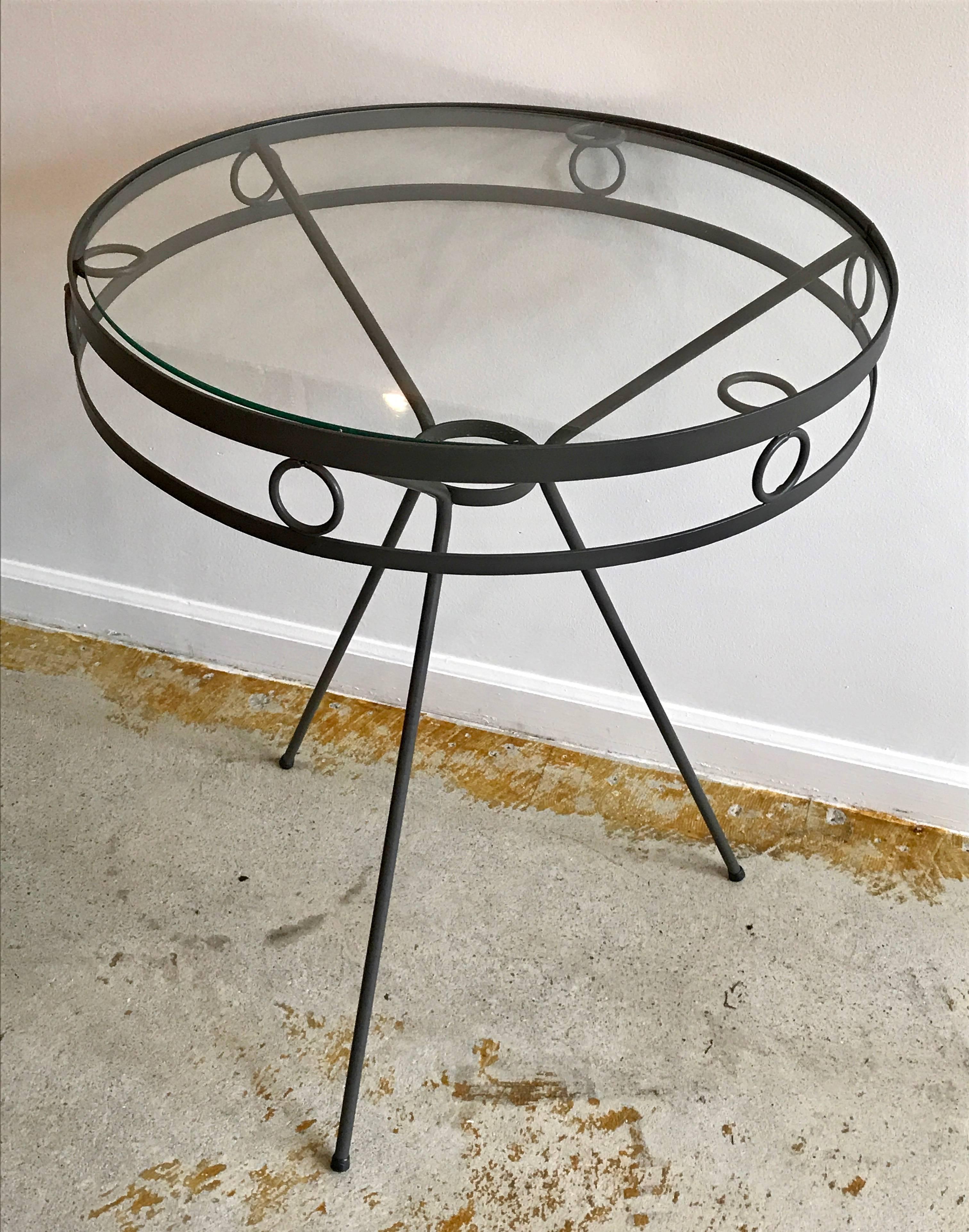 Very cool 1950s metal side tables or cafe tables with tripod legs and round ring accents. Freshly painted anodized bronze. Indoor/ outdoor. Minor surface scratches on glass tops.