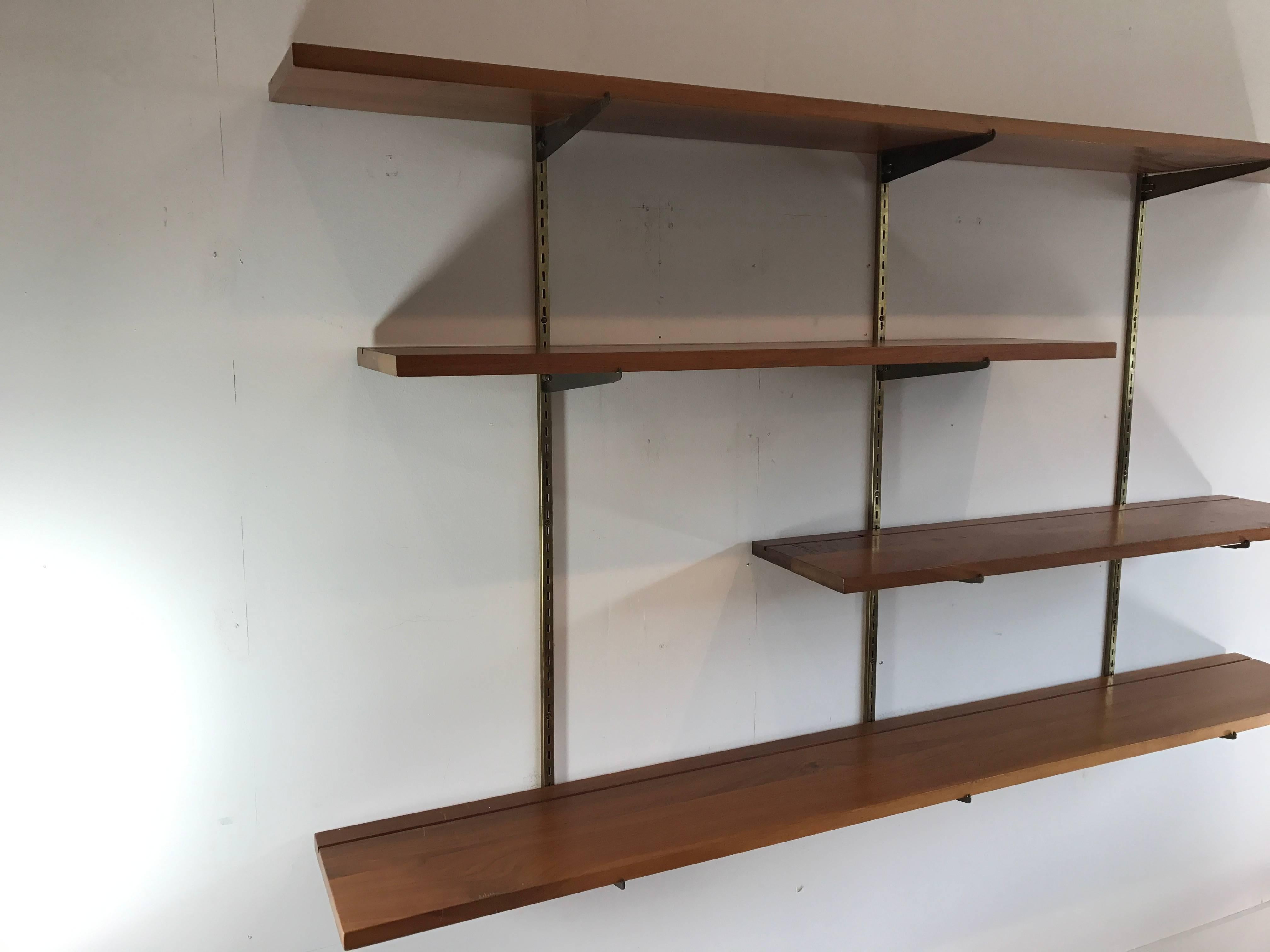 Beautiful and minimal walnut shelf unit with solid brass brackets and hardware by George Nelson. Can configure multiple ways. Shelves are solid walnut and have original finish. Surface scratches, but no structural issues, one smaller shelf has