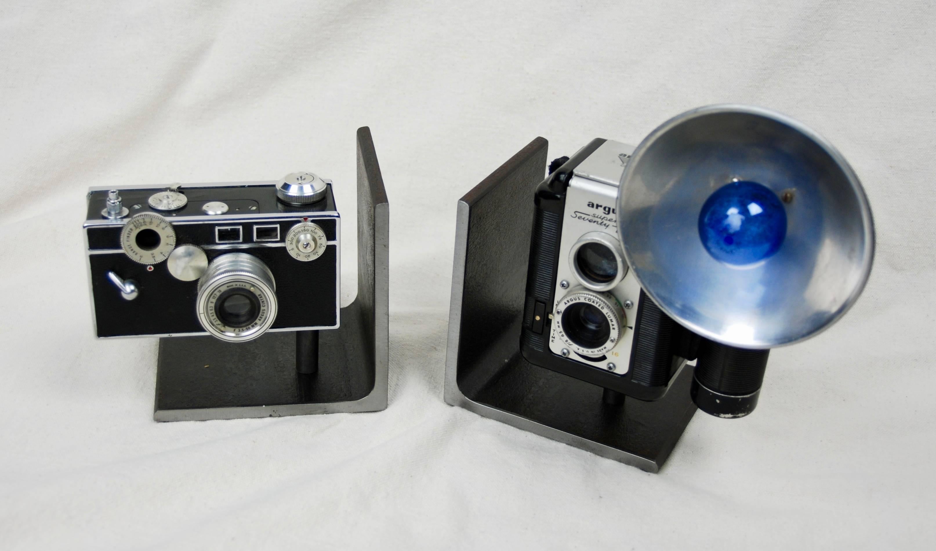 Vintage cameras made into bookends by American artist Breck Armstrong. Cameras attached to heavy steel base.