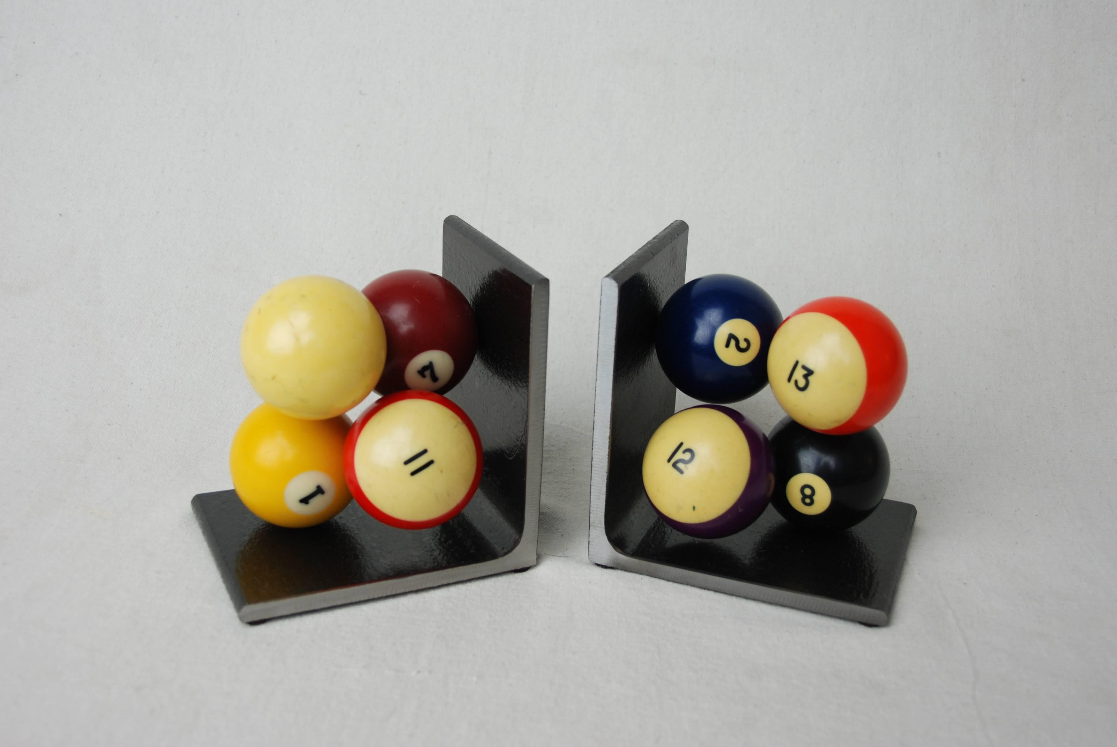 Vintage billiard balls made into bookends by American artist Breck Armstrong. Balls attached to heavy steel base.