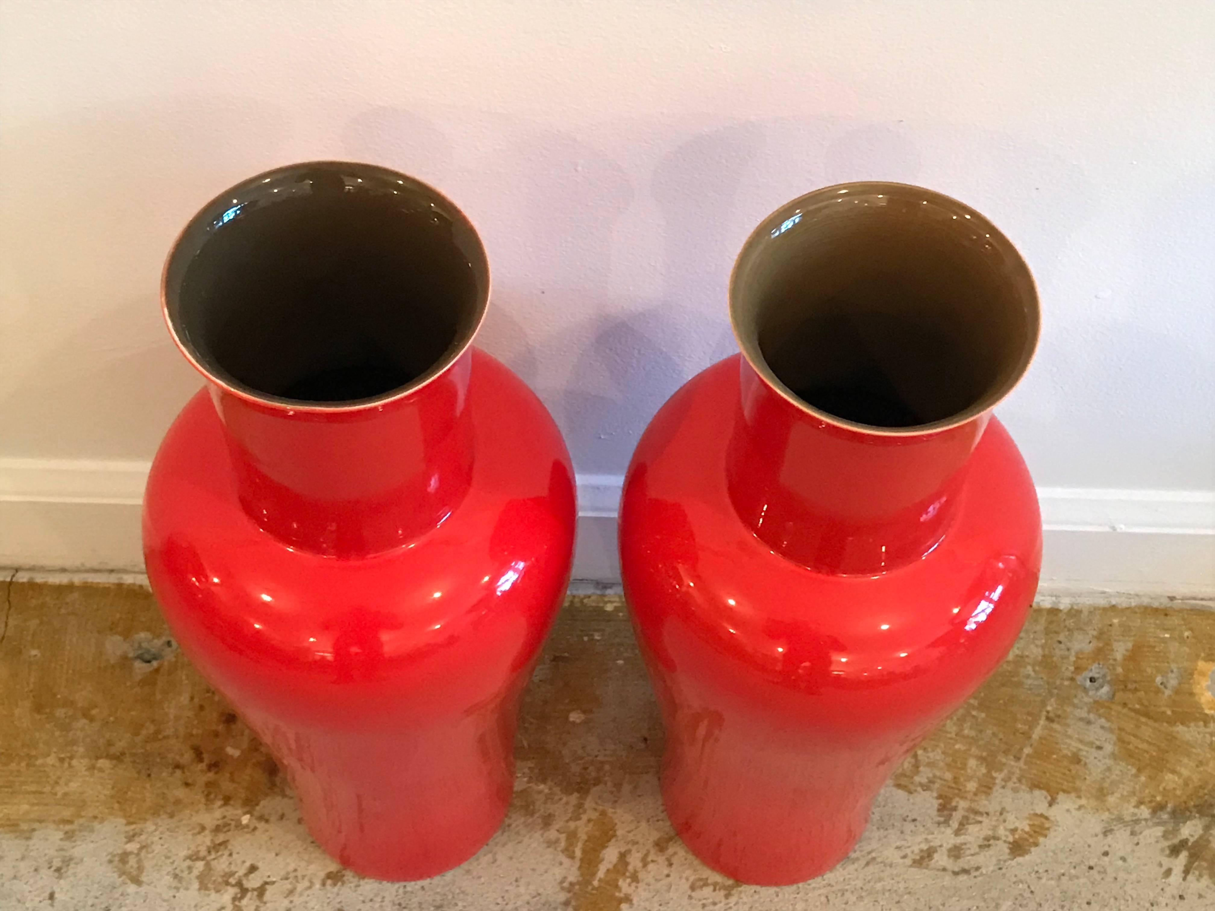 Stunning Pair of handcrafted modern porcelain vases by Artist Bo Jai for Middle Kingdom. 15 inches x 6 inch. Vibrant red with contrasting rich brown interior. The vases are kiln fired in Jingdezhen China. Each piece signed by the artist. Exceptional