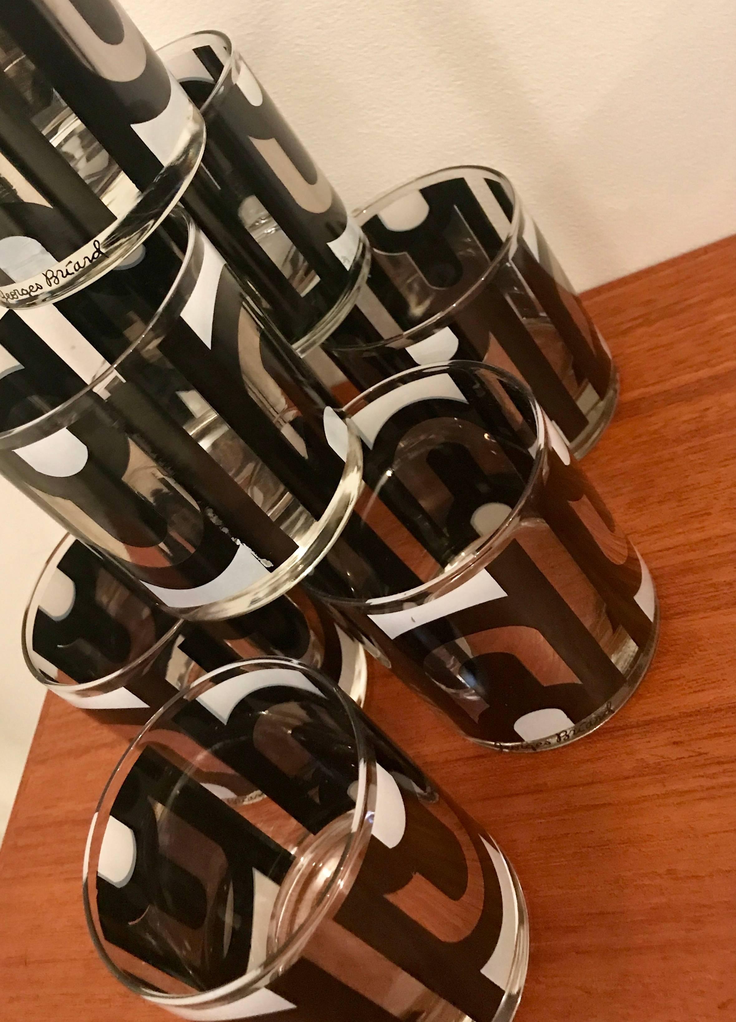 Very chic set of eight cocktail rock glasses by American designer Georges Briard. The pattern is called Metric Maroon Executive, a clean curved design consisting of black, white and silver metallic.