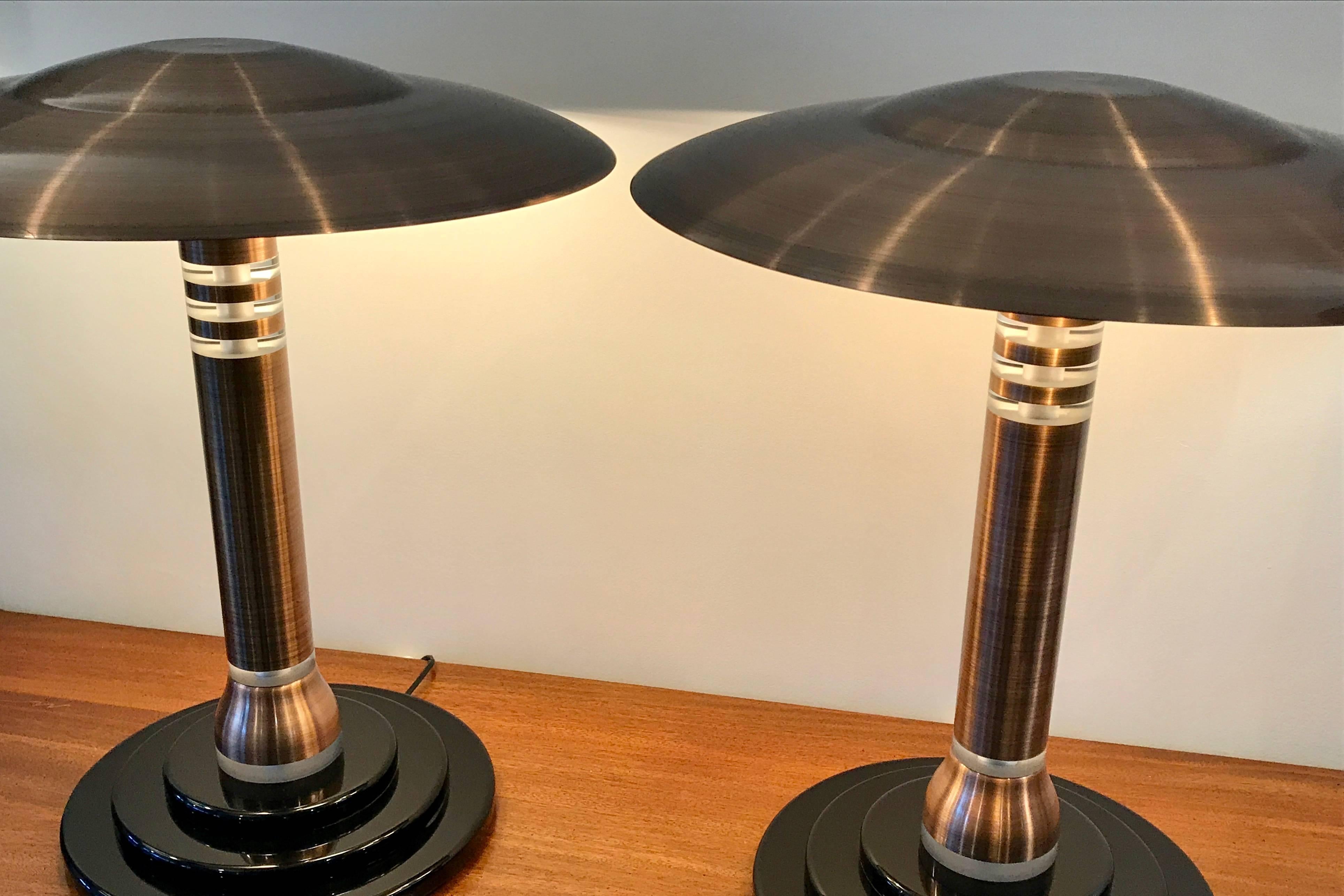 Massive pair of Art Deco style table lamps.  Very heavy, made of metal and lucite mounted on a three tier circular base.  The finish on the metal is a high gloss brushed copper color.  Maker unknown but very high quality.