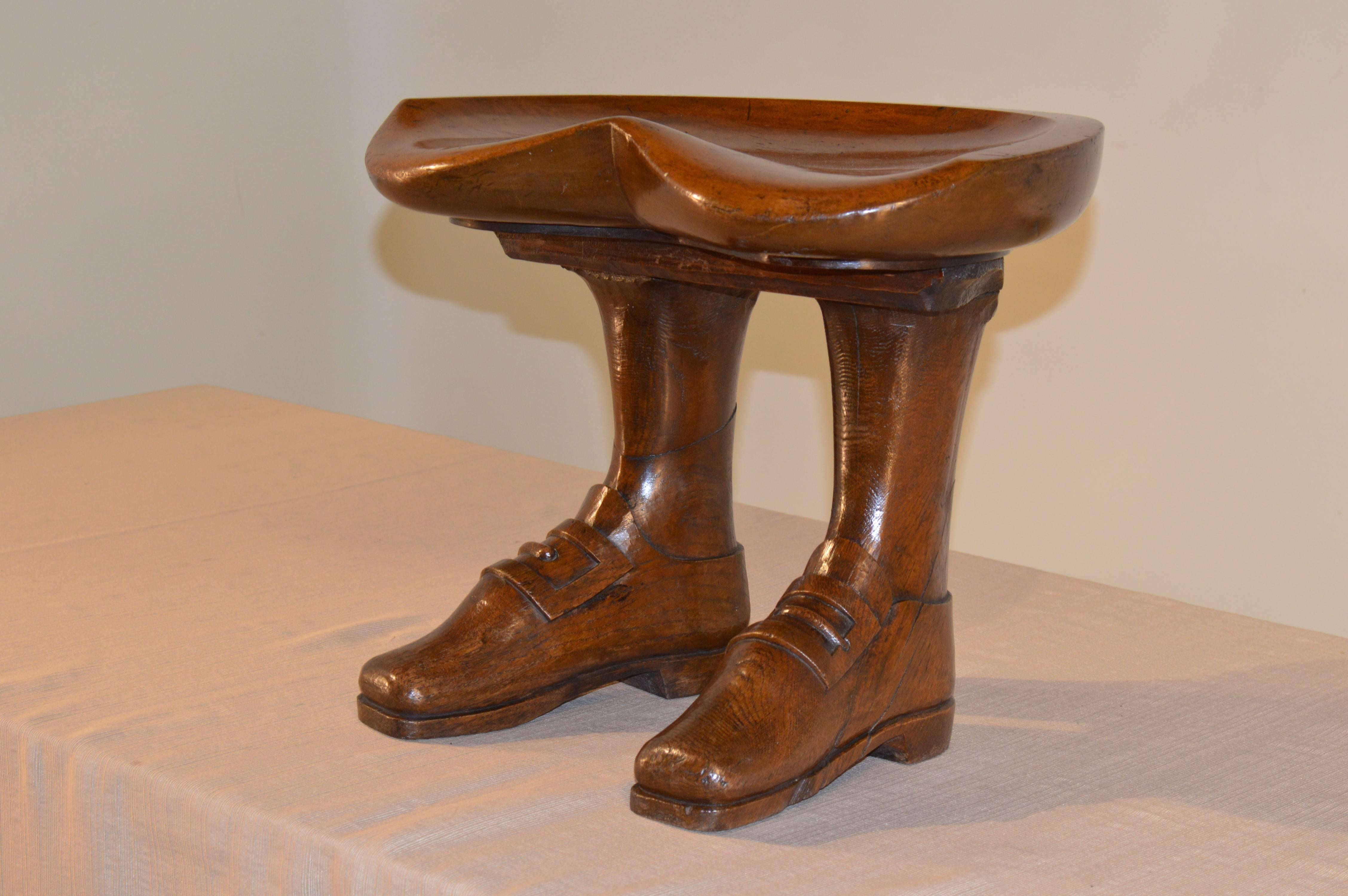 19th century English stool made from walnut. The seat is shaped and is supported upon two legs, which end in buckle-shoe 
