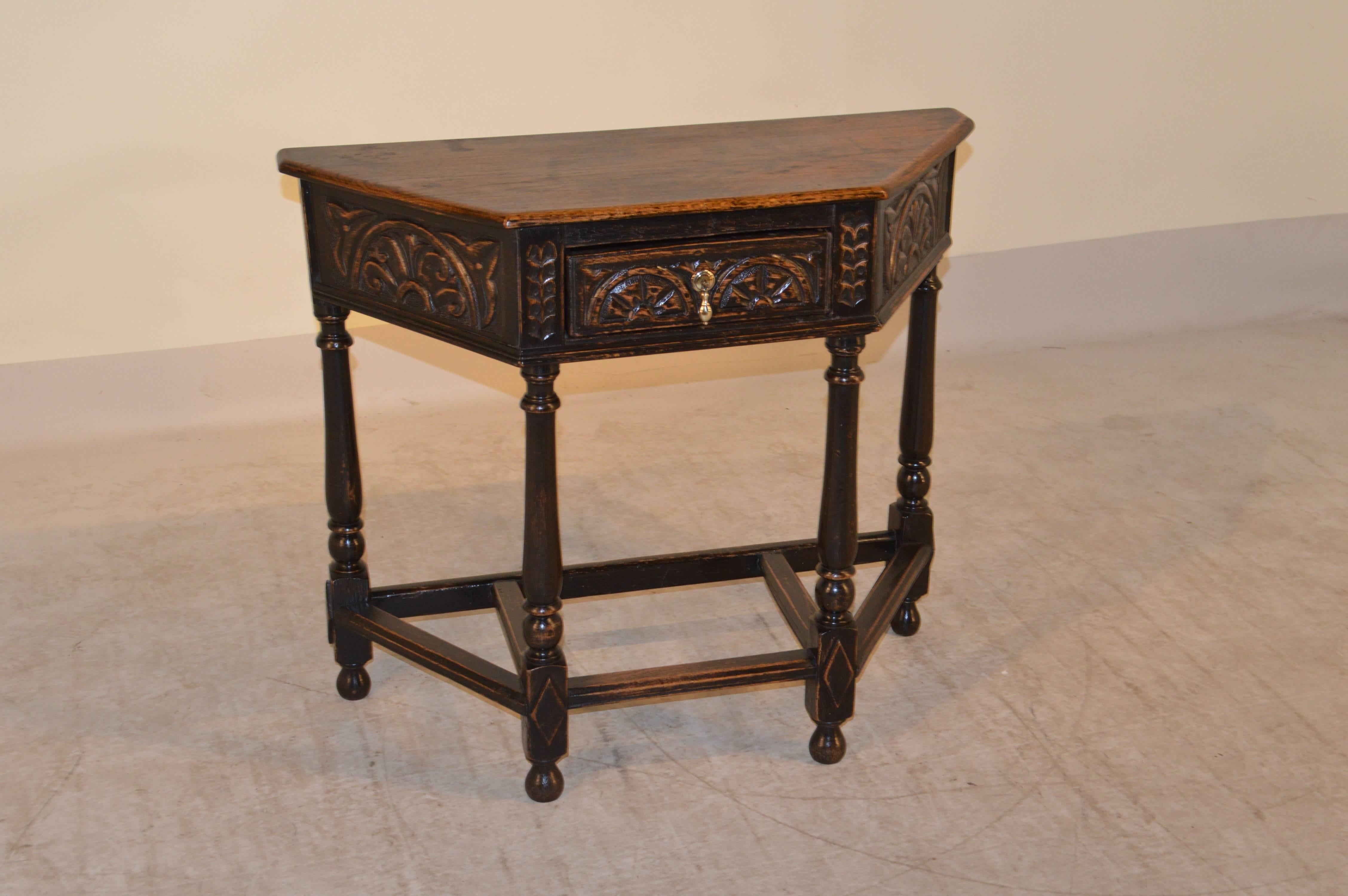 18th century English oak five-sided table with a beveled edge around the top following down to a carved apron which contains a single drawer. The piece is supported on turned legs, joined by stretchers and raised on turned feet.