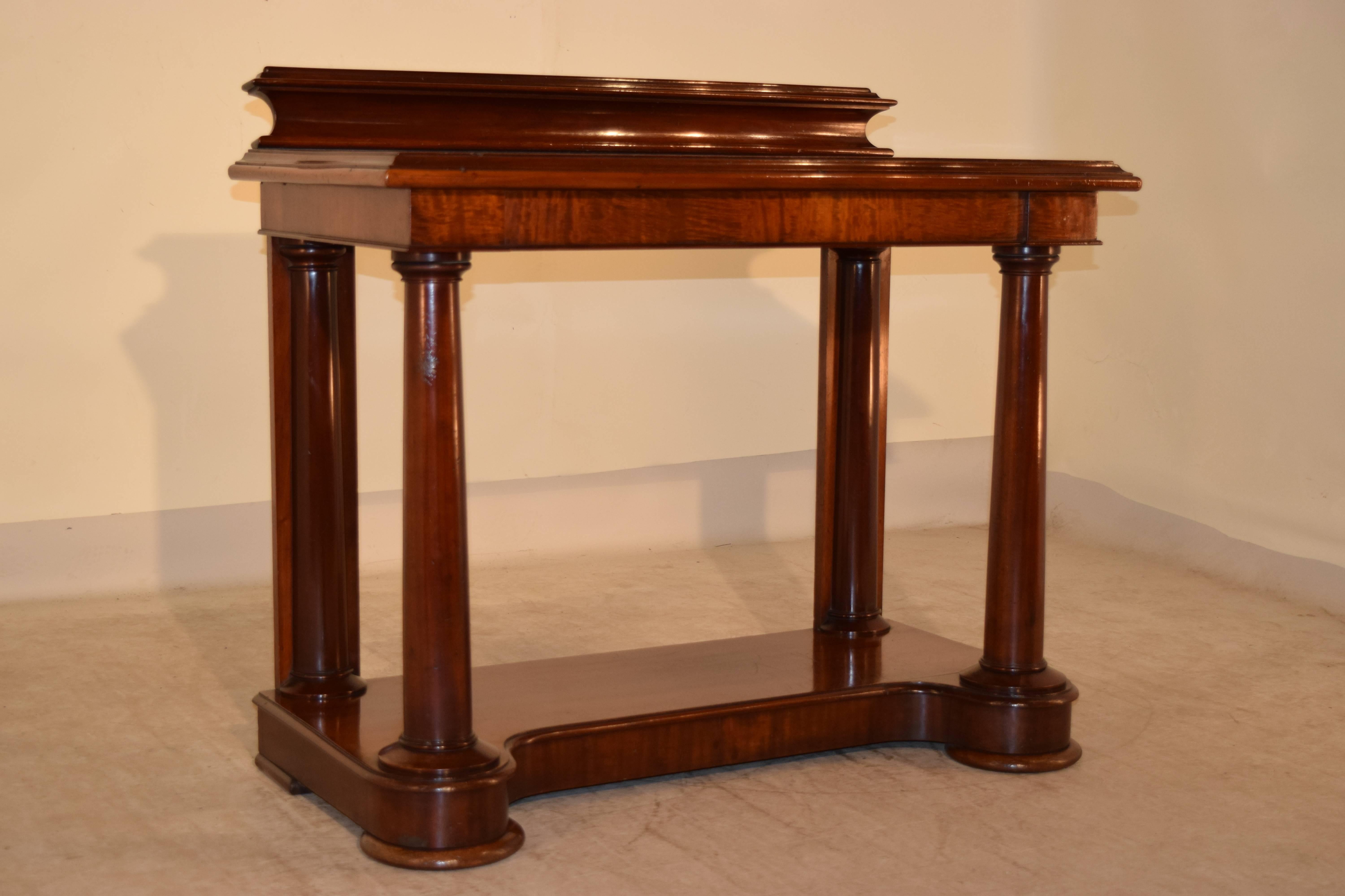 19th century English mahogany console table with a lovely molded backsplash over a gorgeous top with a molded edge and a single drawer in the apron. The piece is supported on hand-turned columns in the front and flat back legs with applied half