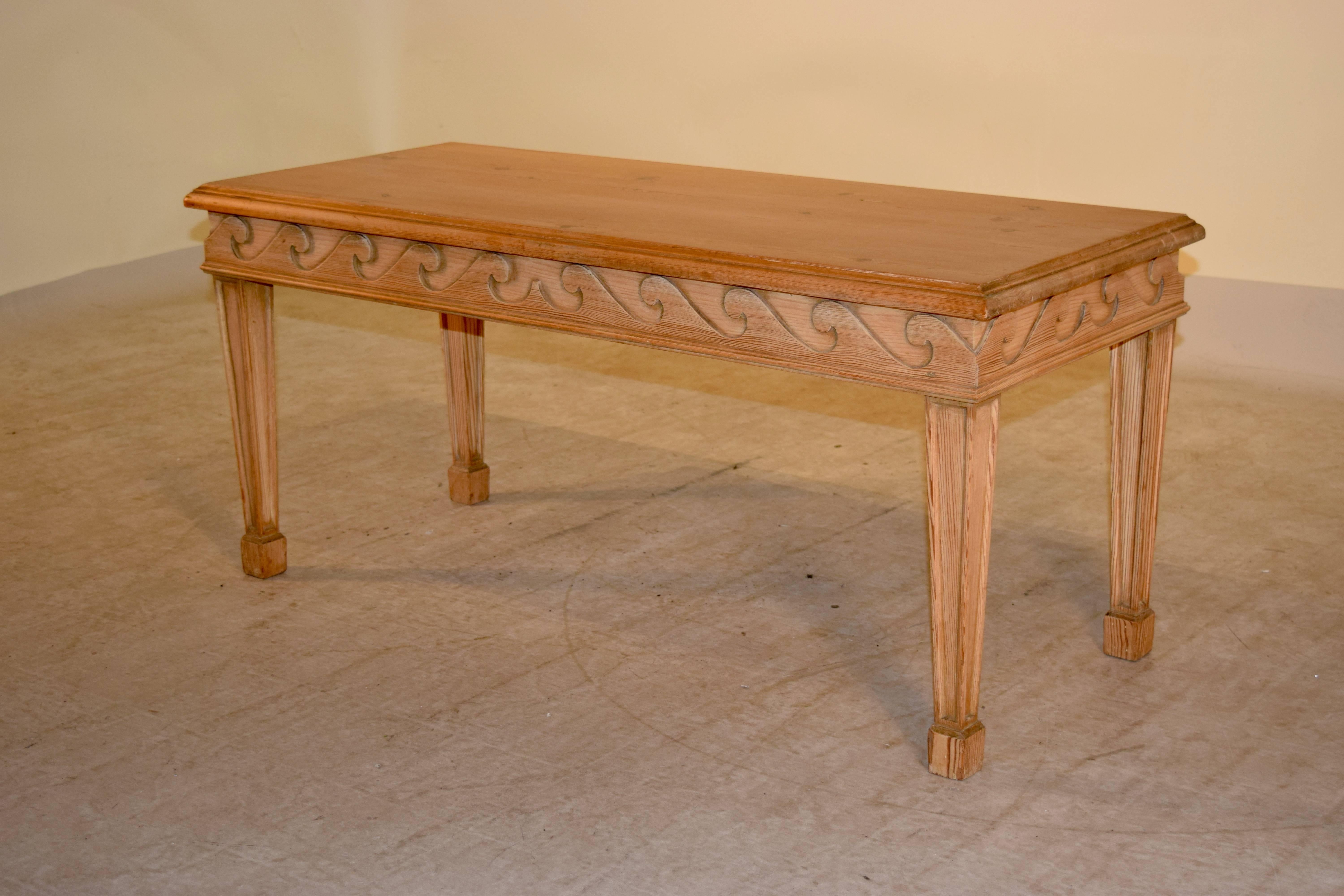 Late 19th century French cocktail table made from pitch pine. The top has two small repairs and has a beveled edge, following down to a swan's neck shaped carved decorated apron, supported on paneled tapered legs, ending in blocked feet.
