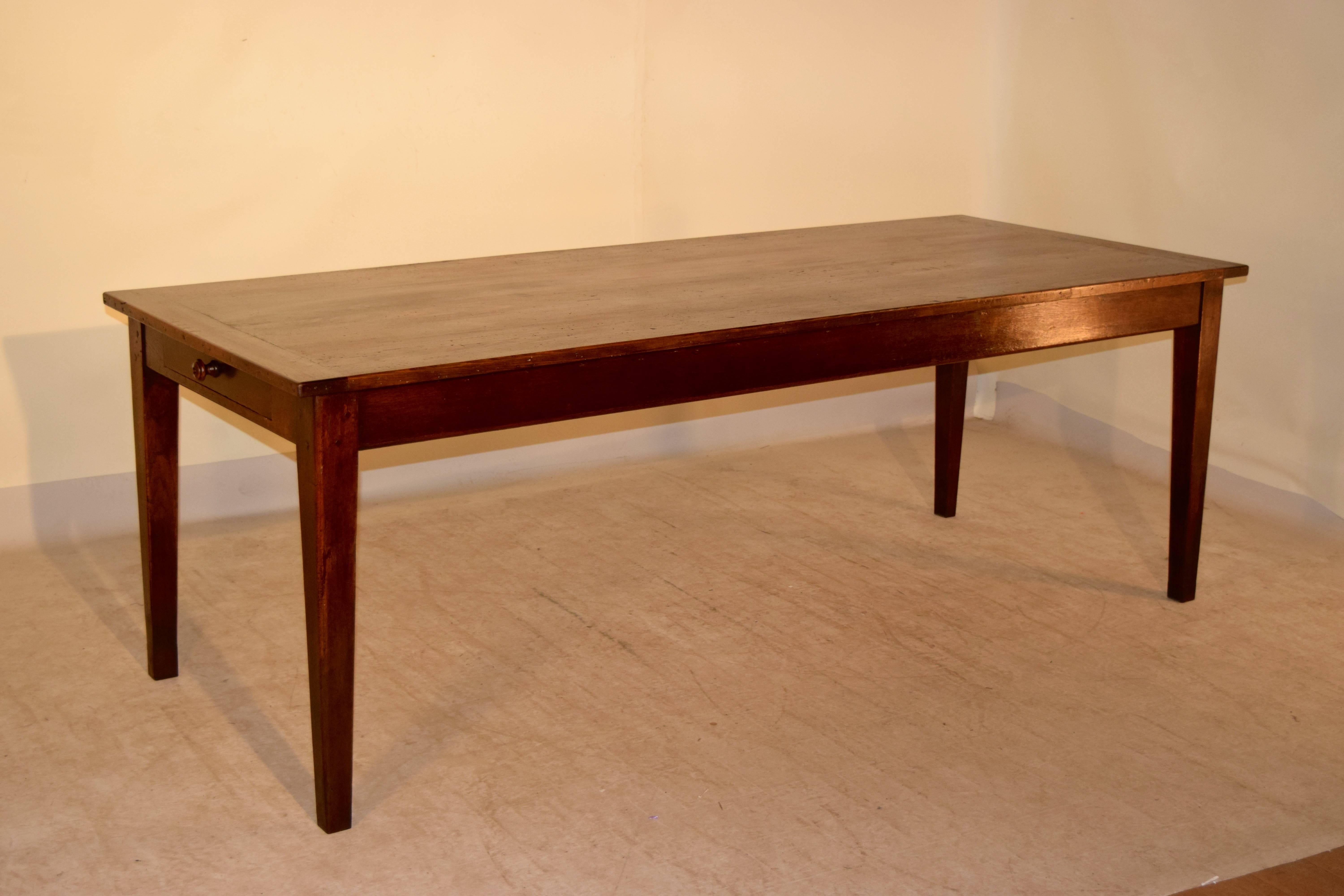 19th century French farm table with a pine top which has bread board ends. The base is made of oak and has a simple apron and has a large drawers, one on each end supported on simple tapered legs. The apron measures 24.88