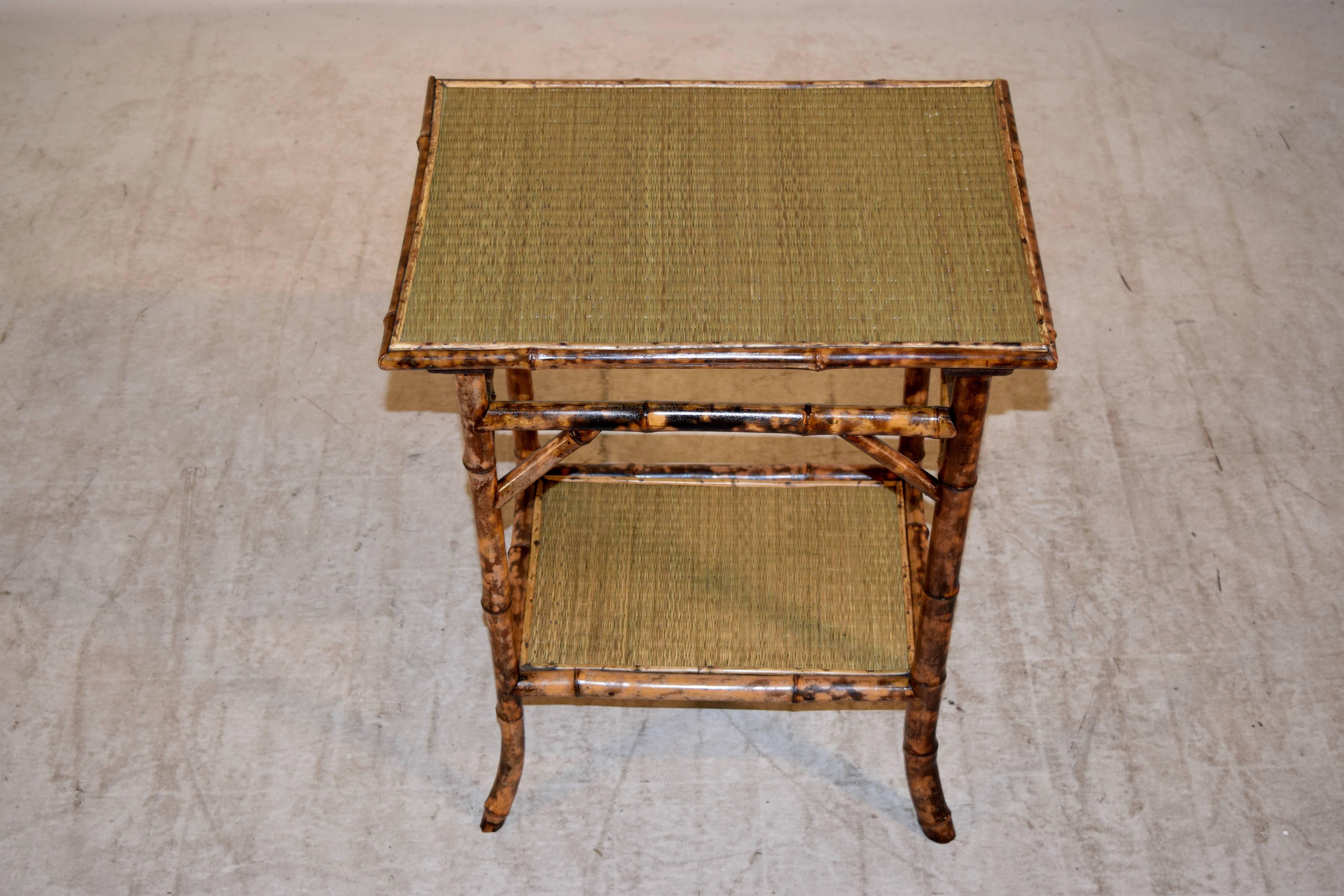 19th century French side table made from tortoise bamboo with splayed legs and rush covered top and lower shelf.