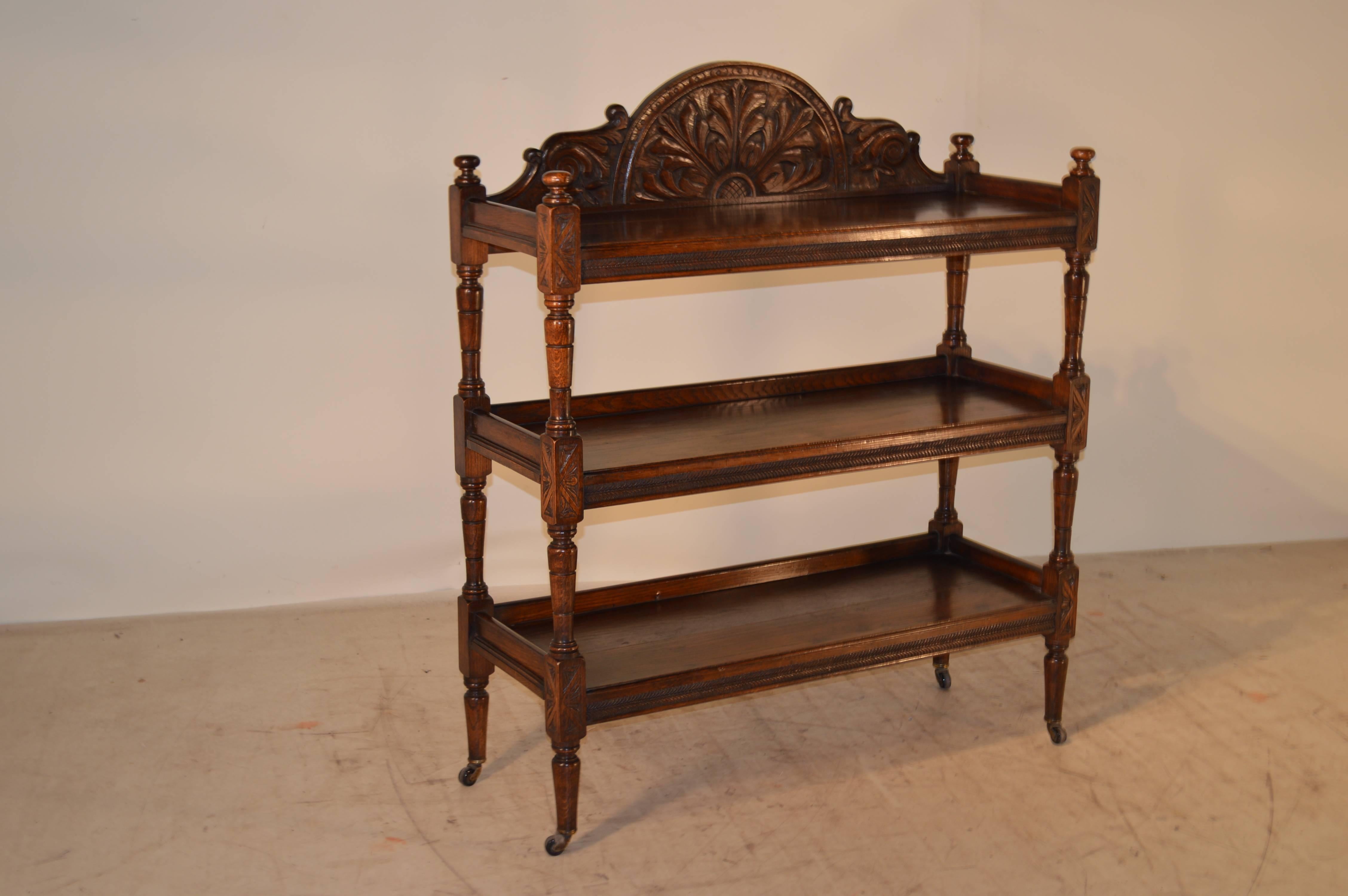 19th century French dumbwaiter made from oak with lovely carved backsplash and three shelves with carved decoration on fronts of shelves. Nicely turned shelf supports and legs supported on casters.