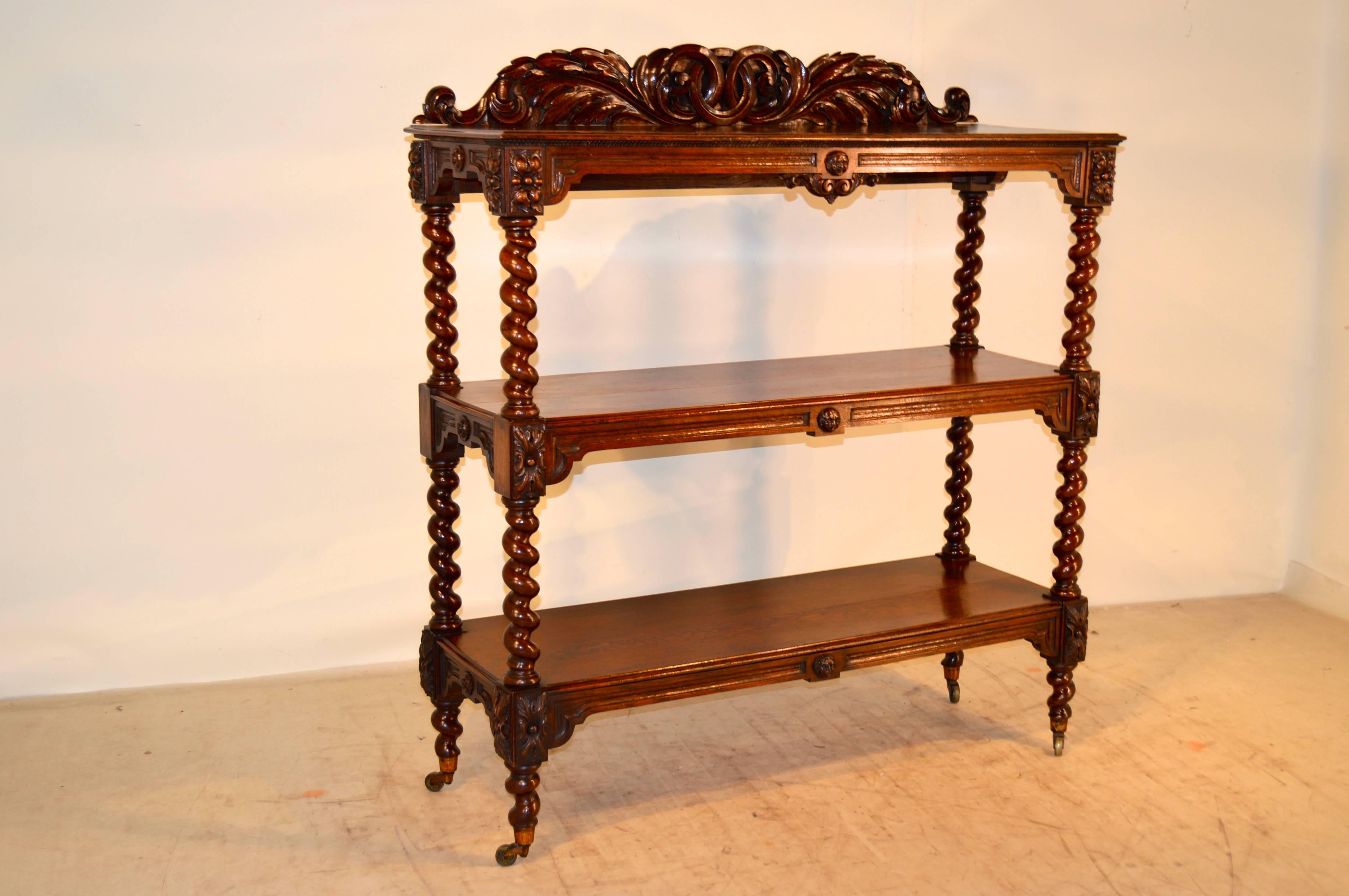 Large 19th century French oak dumbwaiter. The backsplash is carved with an acanthus leaf and joined ring decoration, following down to three shelves, all with beveled edges and separated with hand-turned barley-twist shelf supports. Each shelf has a