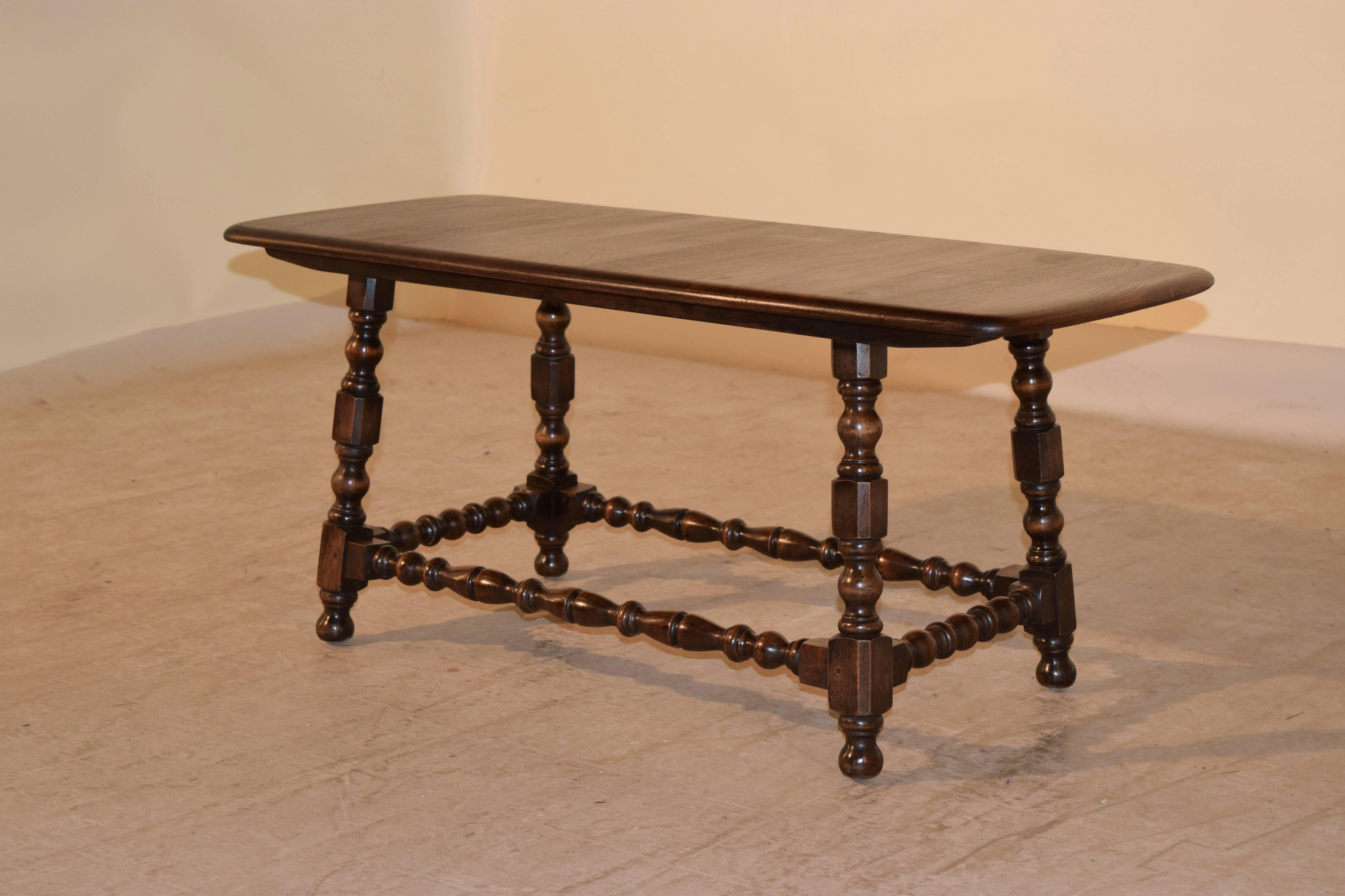 Mid-20th century English coffee table with a finely grained elm top, supported on turned oak legs, which are joined by matching stretchers and turned feet.