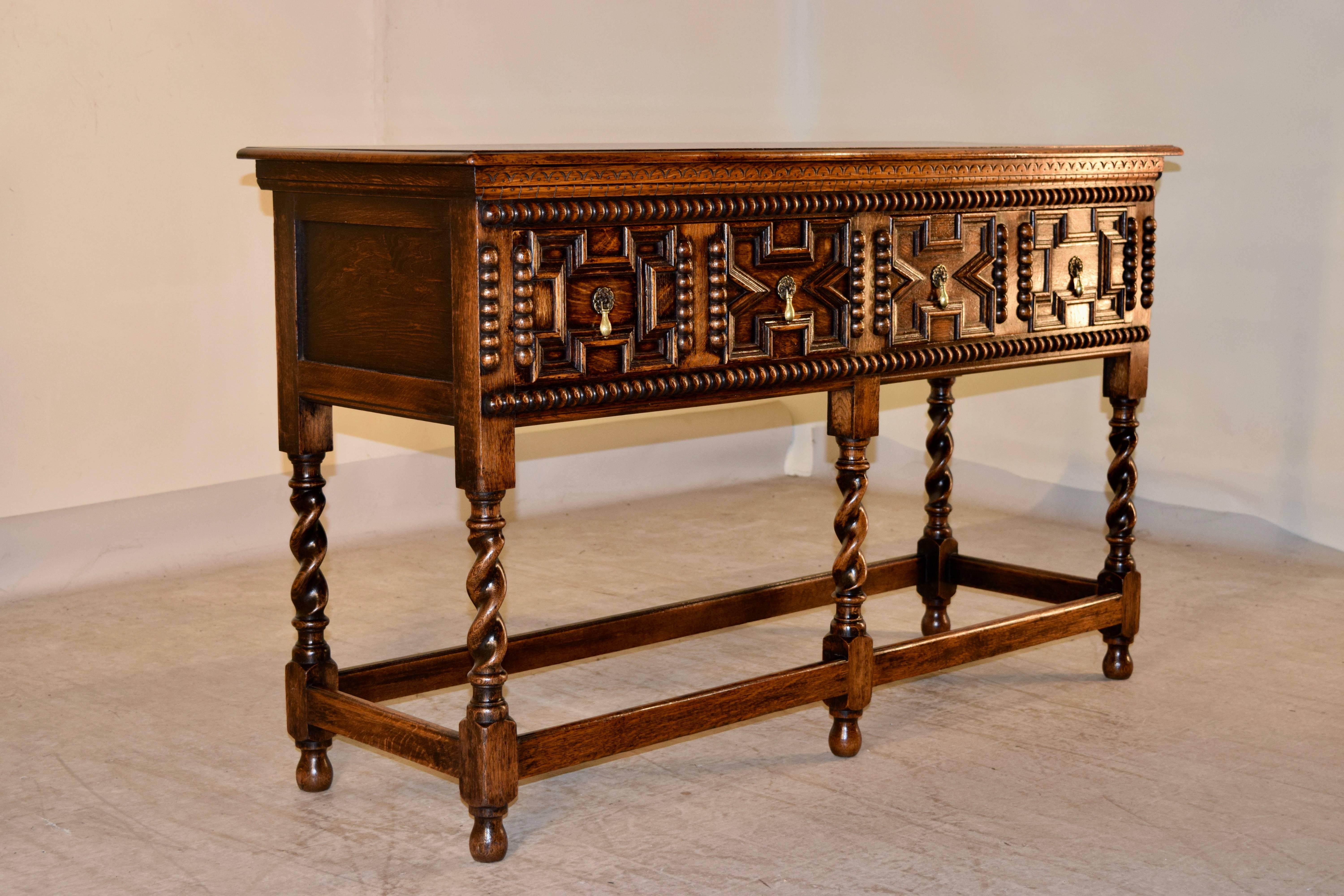 Late 19th century English oak sideboard with a beveled edge around the top, following down to two drawers in the front with hand paneled drawer fronts with beading. The case has wonderfully hand carve details and embellishments. The legs are