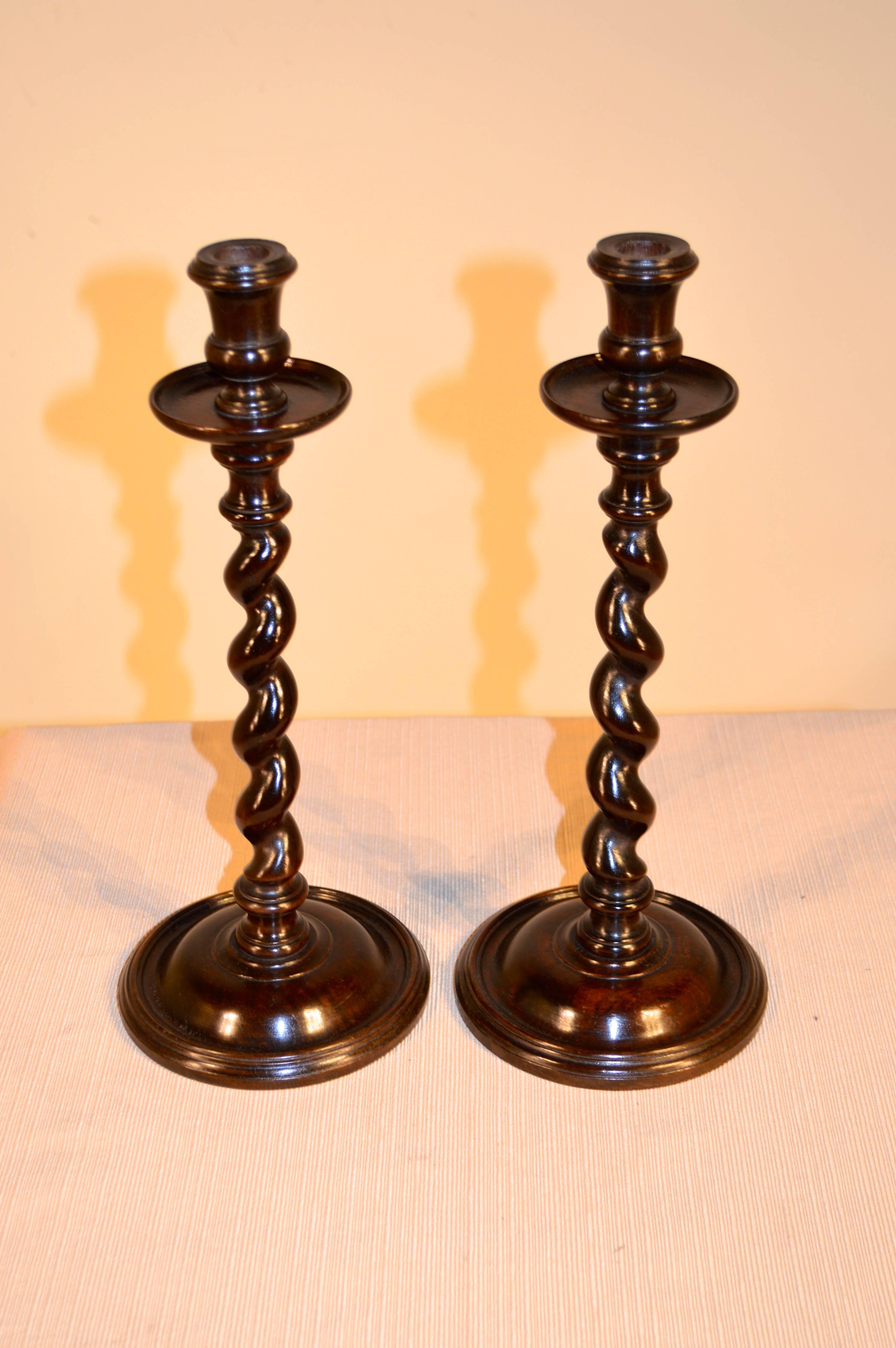 Pair of English oak candlesticks with hand-turned candle cups and bobeches, following down to hand-turned barley twist stems and bases, circa 1890.