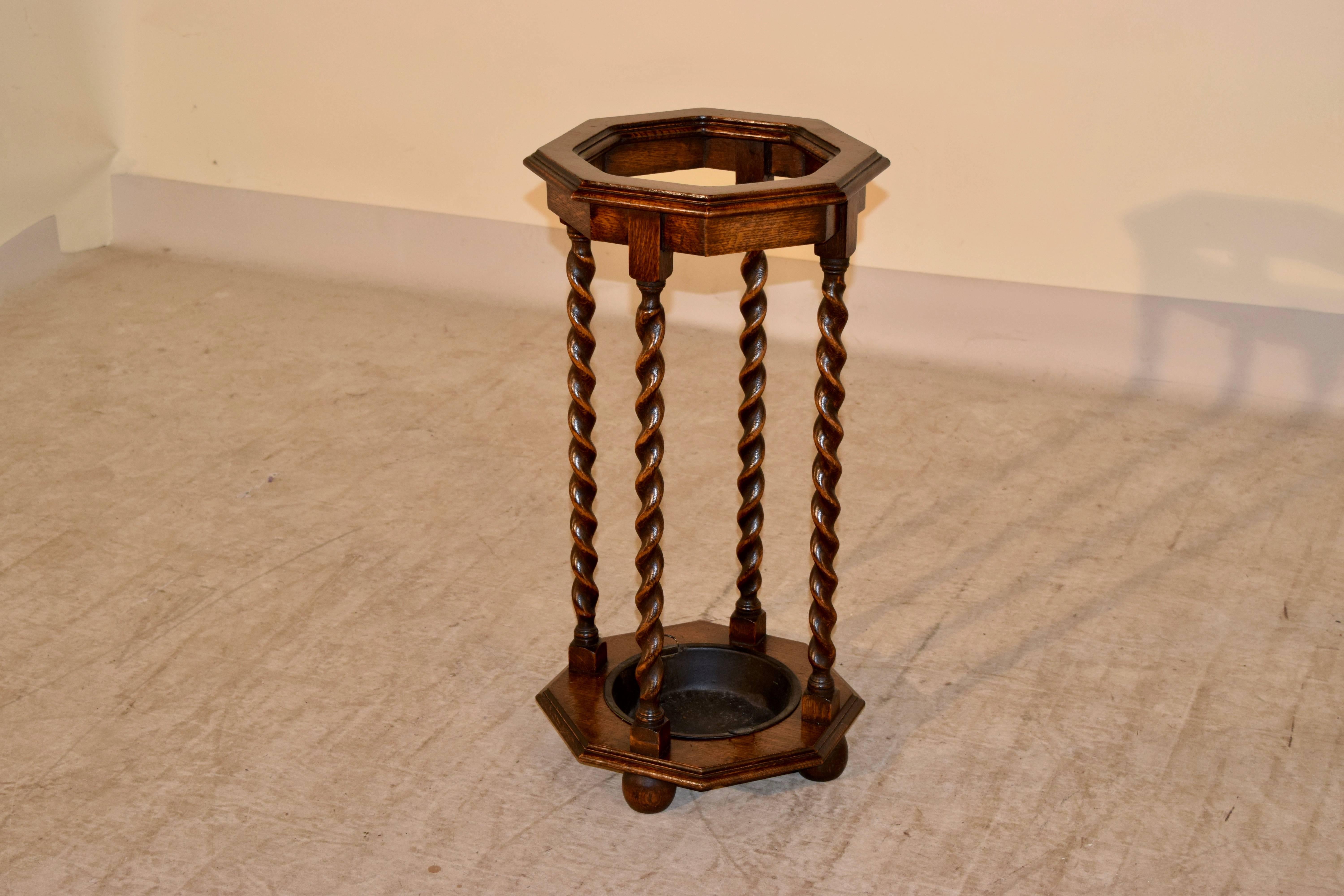 Late 19th Century English oak umbrella stand with an octagonal shaped top and base , which are beveled around the edge, and separated by hand-turned barley twist legs.