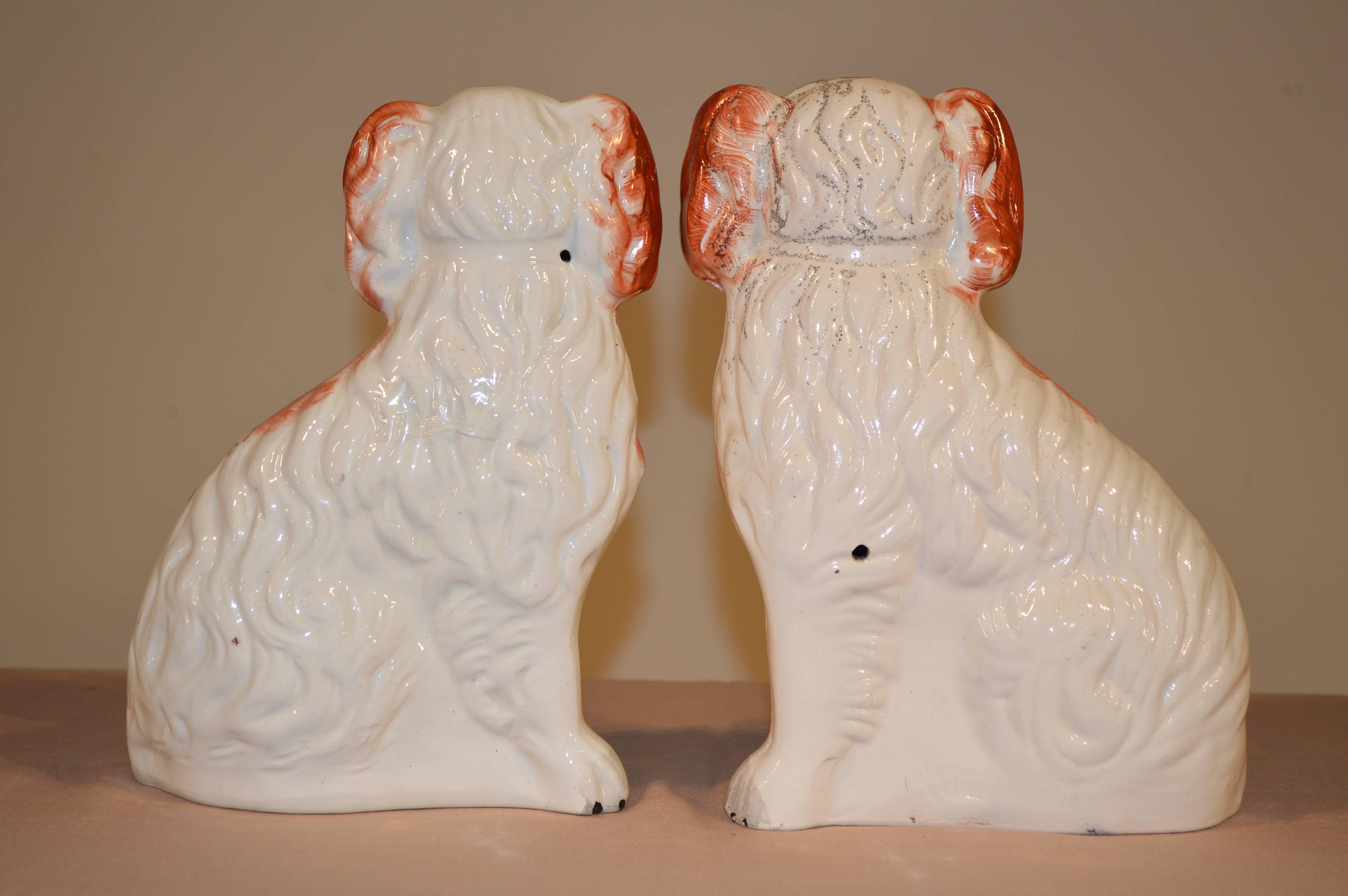 19th century pair of English Staffordshire spaniels in rust and white. Nicely figured mold and wonderful color.
