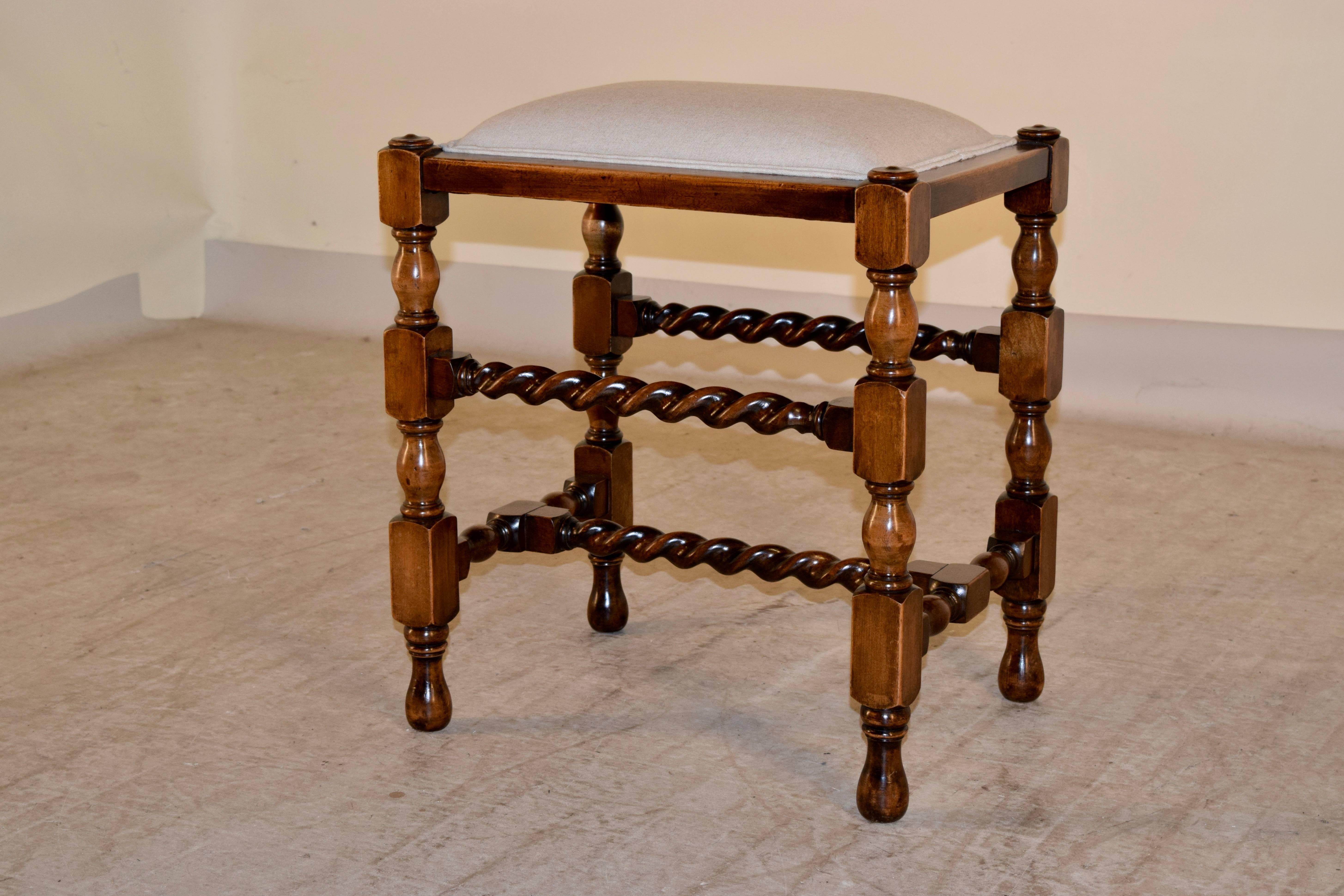 19th century English oak turned stool with a newly upholstered linen seat finished with a double welt. The legs are hand-turned, and are joined by barley twist turned stretchers. Supported on turned feet.