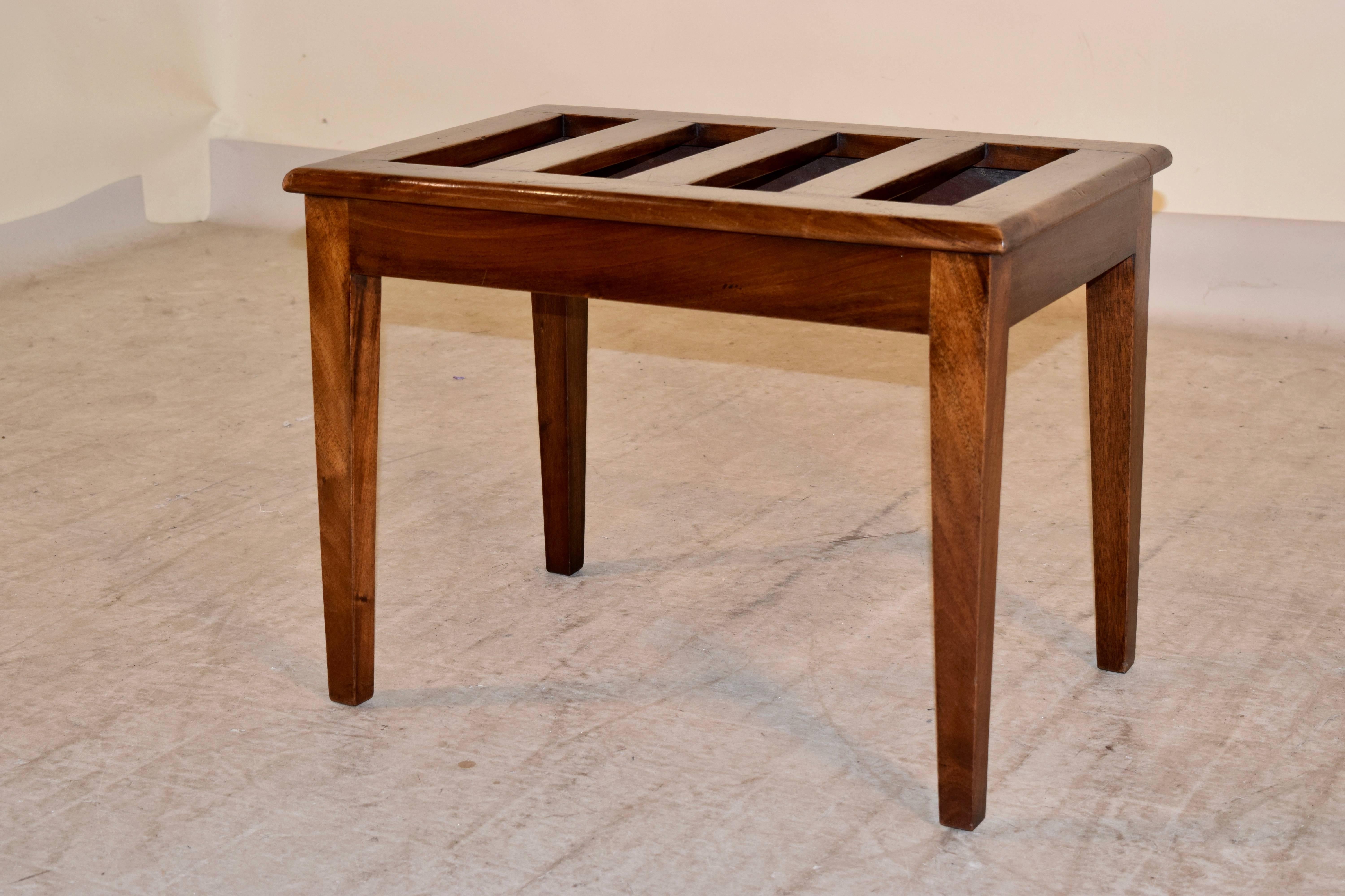 19th century English luggage stand made from mahogany. The stand has very simple lines with a slatted top and tapered legs.