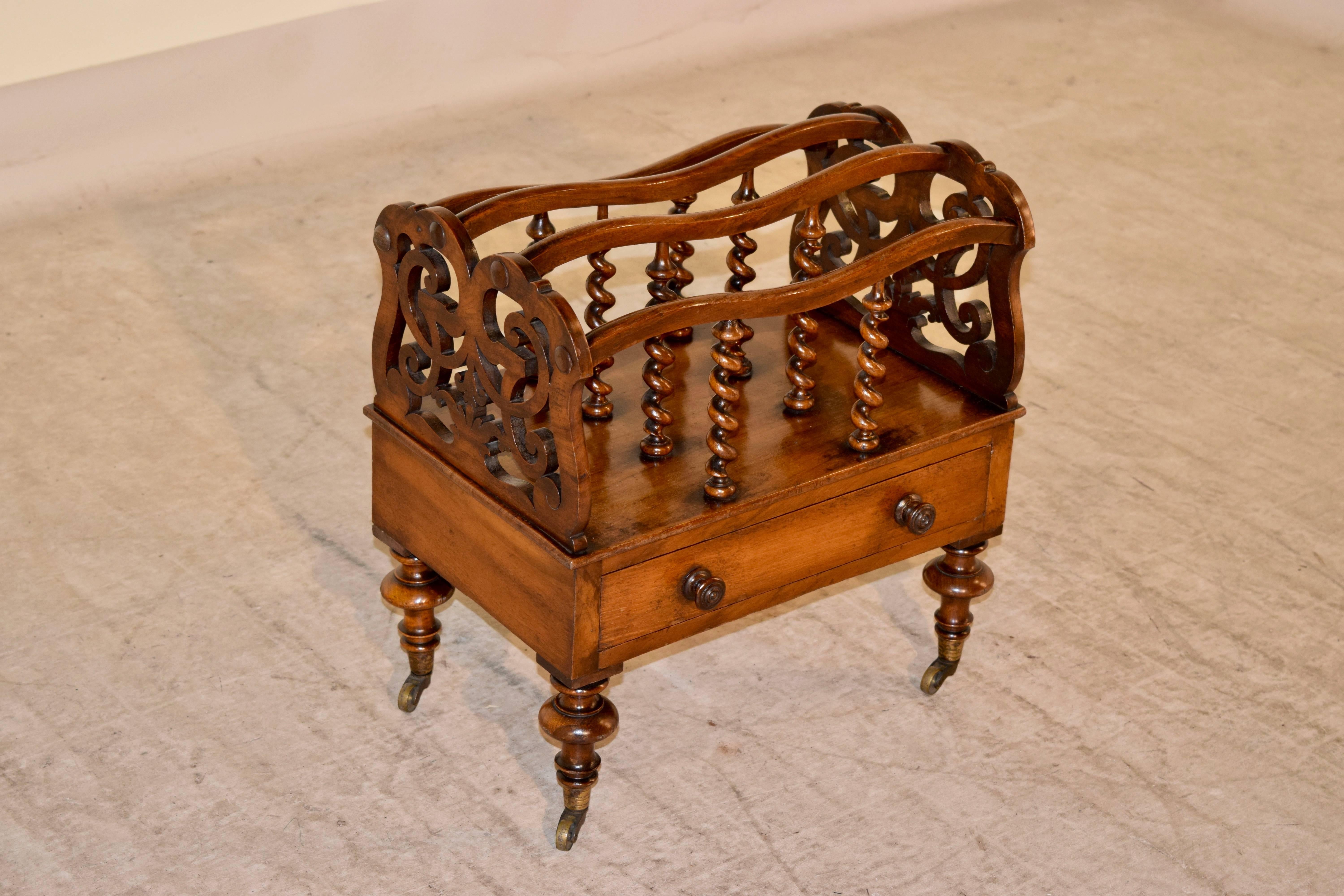 19th century mahogany canterbury from England. The sides are pierced and are joined by serpentine shaped rails, which are connected to the base by hand turned barley twist spindles. The base has a single drawer and the piece is raised on hand turned