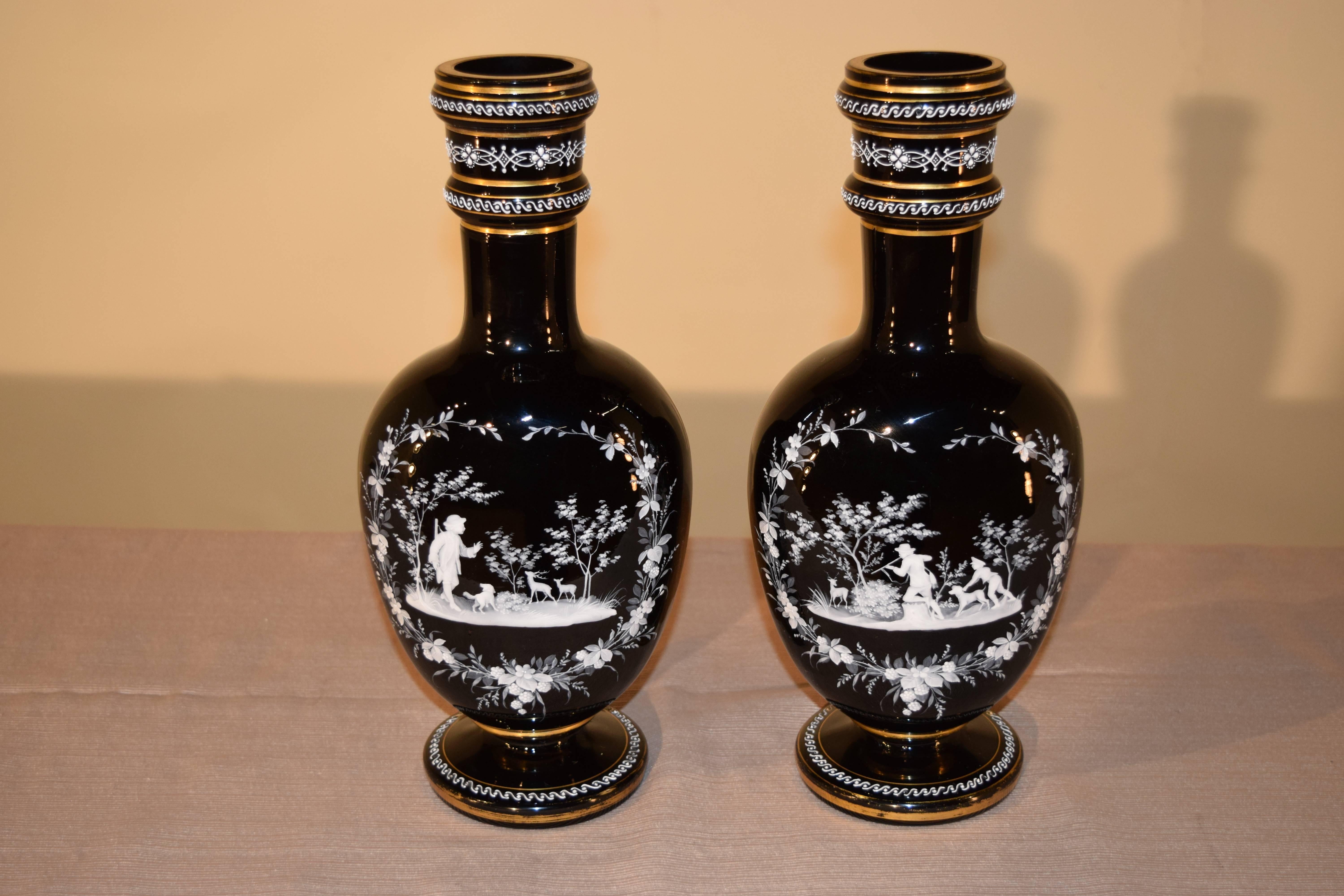 Pair of 19th century handblown amethyst glass vases with central designs on the front surrounded by a floral border and hand-painted scenes depicting children hunting with dogs and deer. The collars and bases of the vases have hand-painted enamel