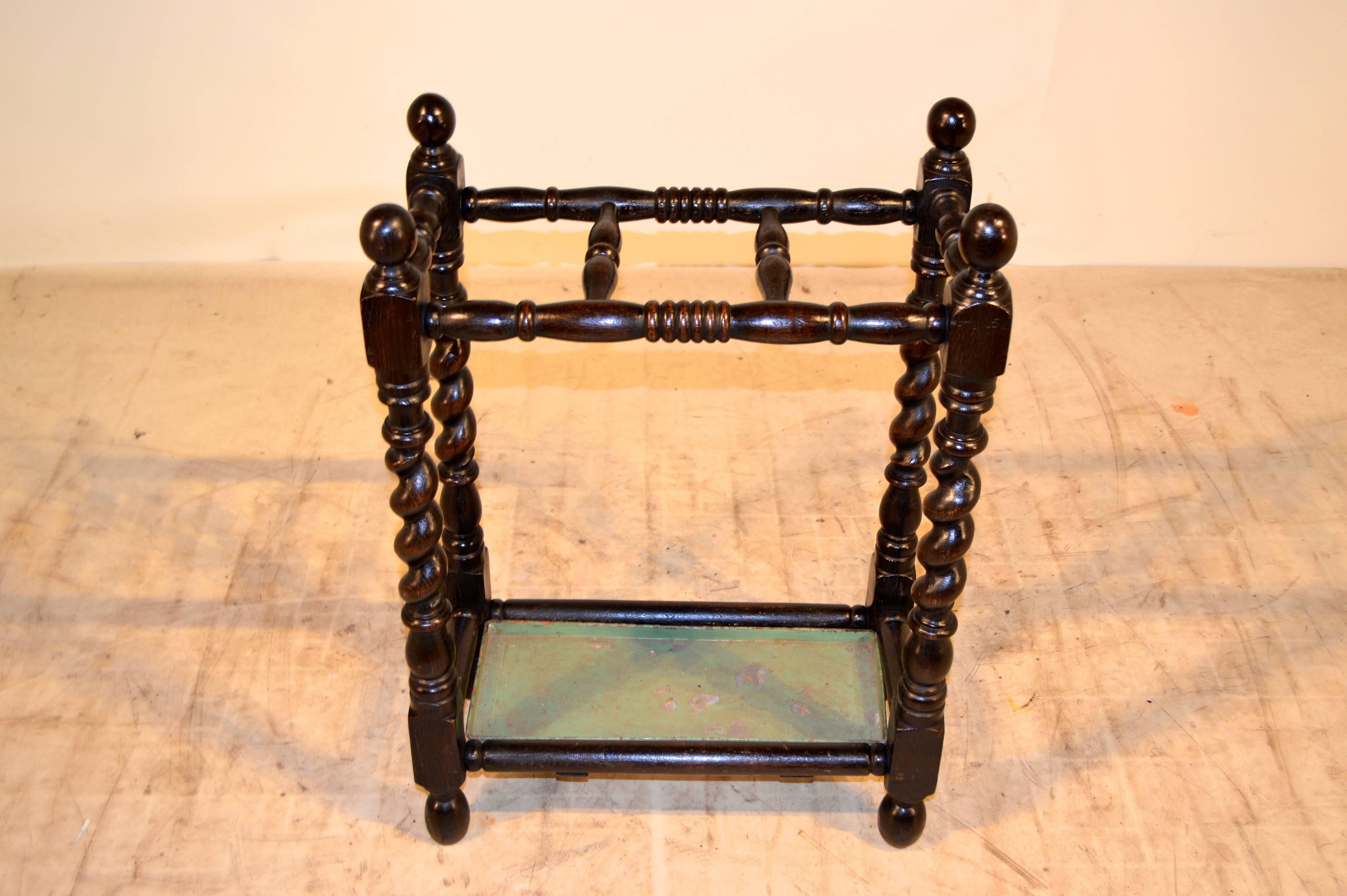 19th century English umbrella stand late 19th century English umbrella stand with nicely turned top rails and finials, following down to hand-turned barley twist legs and turned feet. The original tray has paint loss from normal wear.