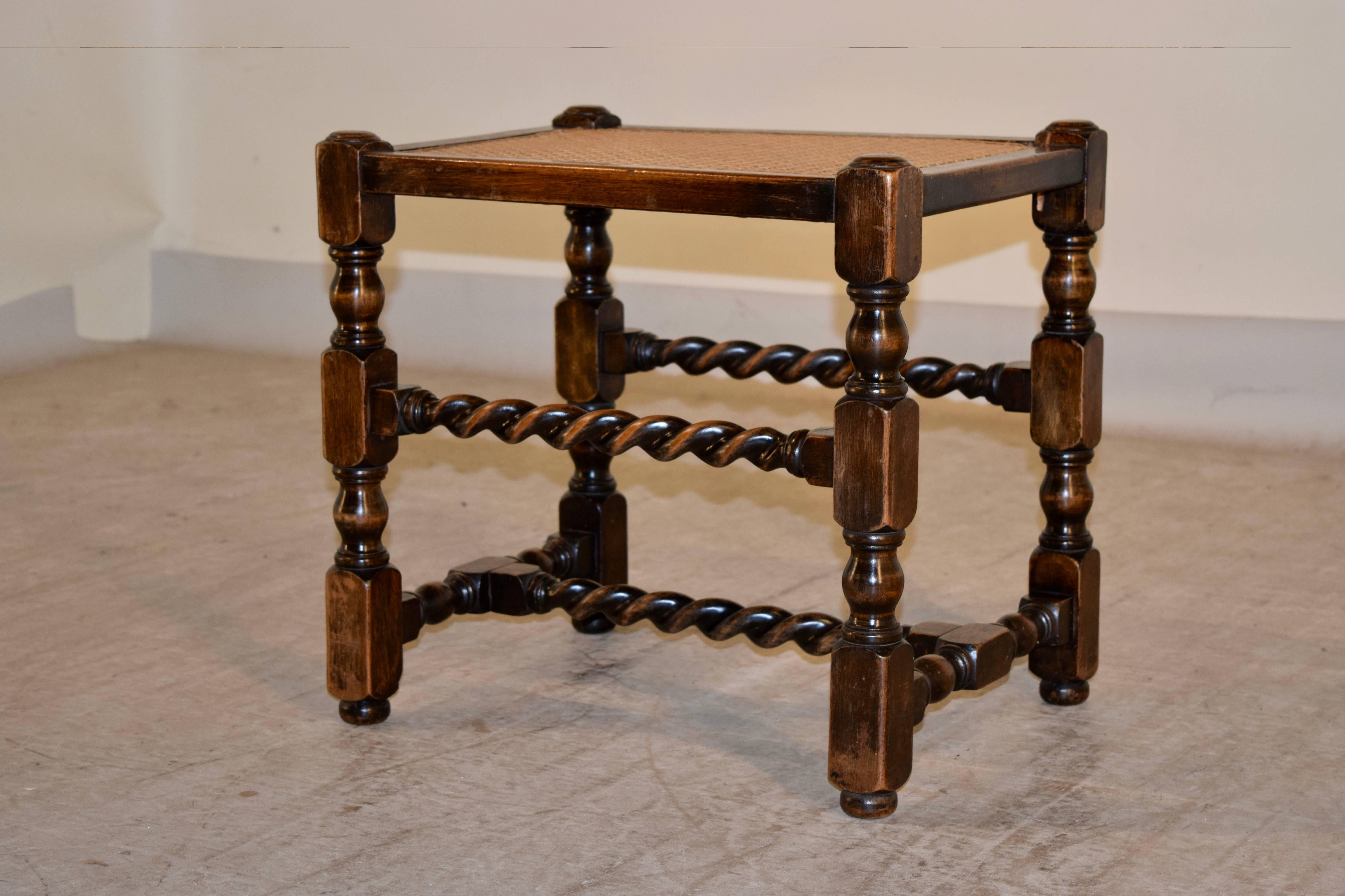 19th century English oak stool with a handwoven cane seat, following down to hand-turned legs, joined by hand-turned barley twist stretchers.