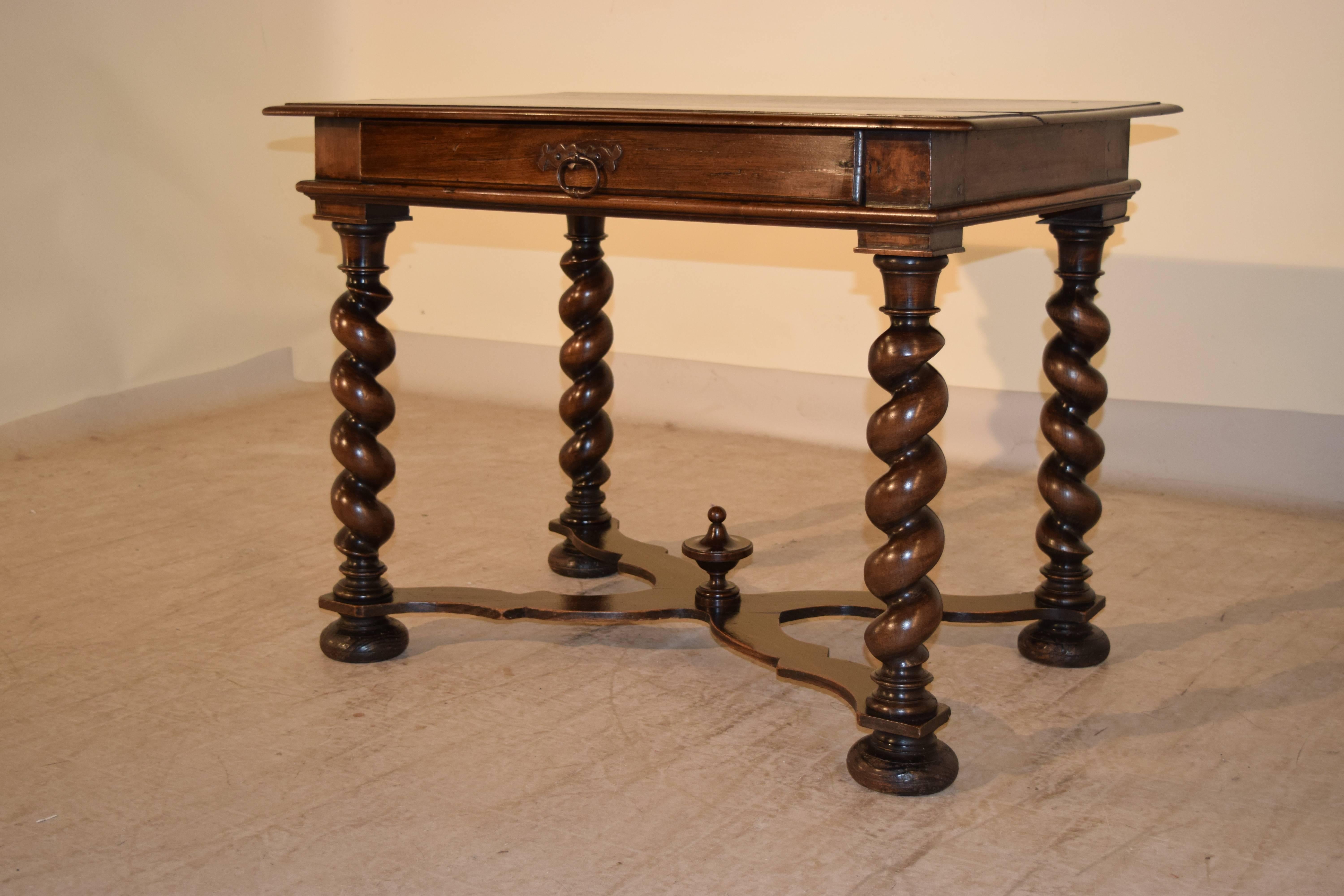 Late 18th century walnut side table from France. The top is beautifully grained and has a bevelled edge, following down to a simple apron and a single drawer in the front, supported on hand-turned barley twist legs, joined by serpentine cross