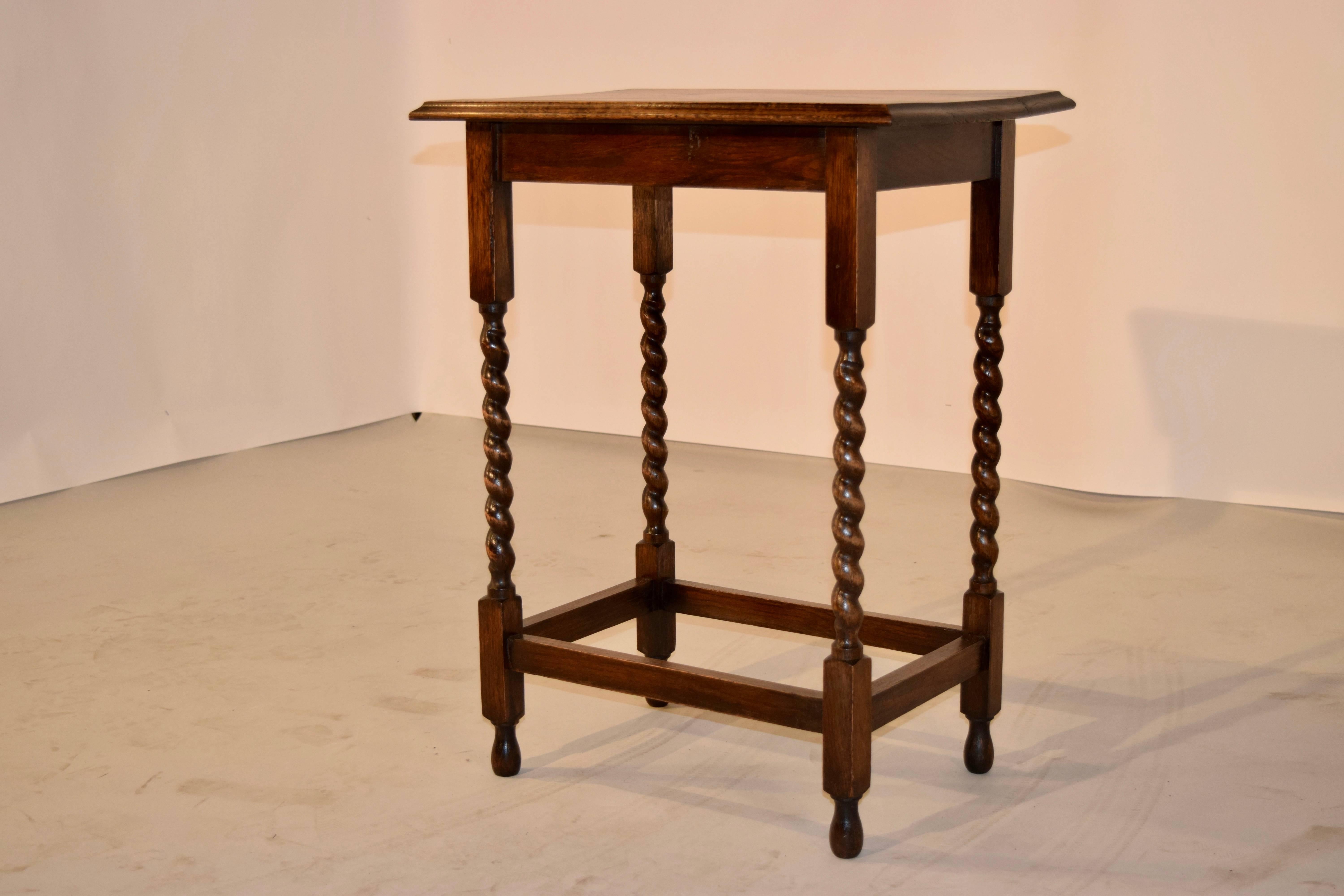English oak side table with a rectangular shaped top which has a bevelled edge, following down to a simple apron and supported on hand-turned barley twist legs, joined by stretchers. Raised on turned feet.