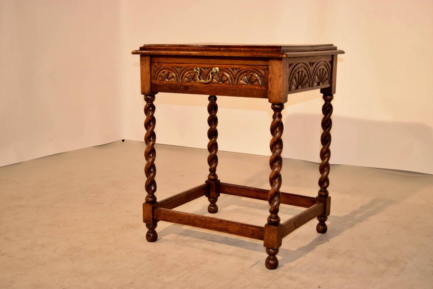 19th century English oak side table with a two board top which has a raised molded edge, following down to lovely carving on all four sides for easy placement in any room. The front contains a single drawer, and the table is raised on hand-turned