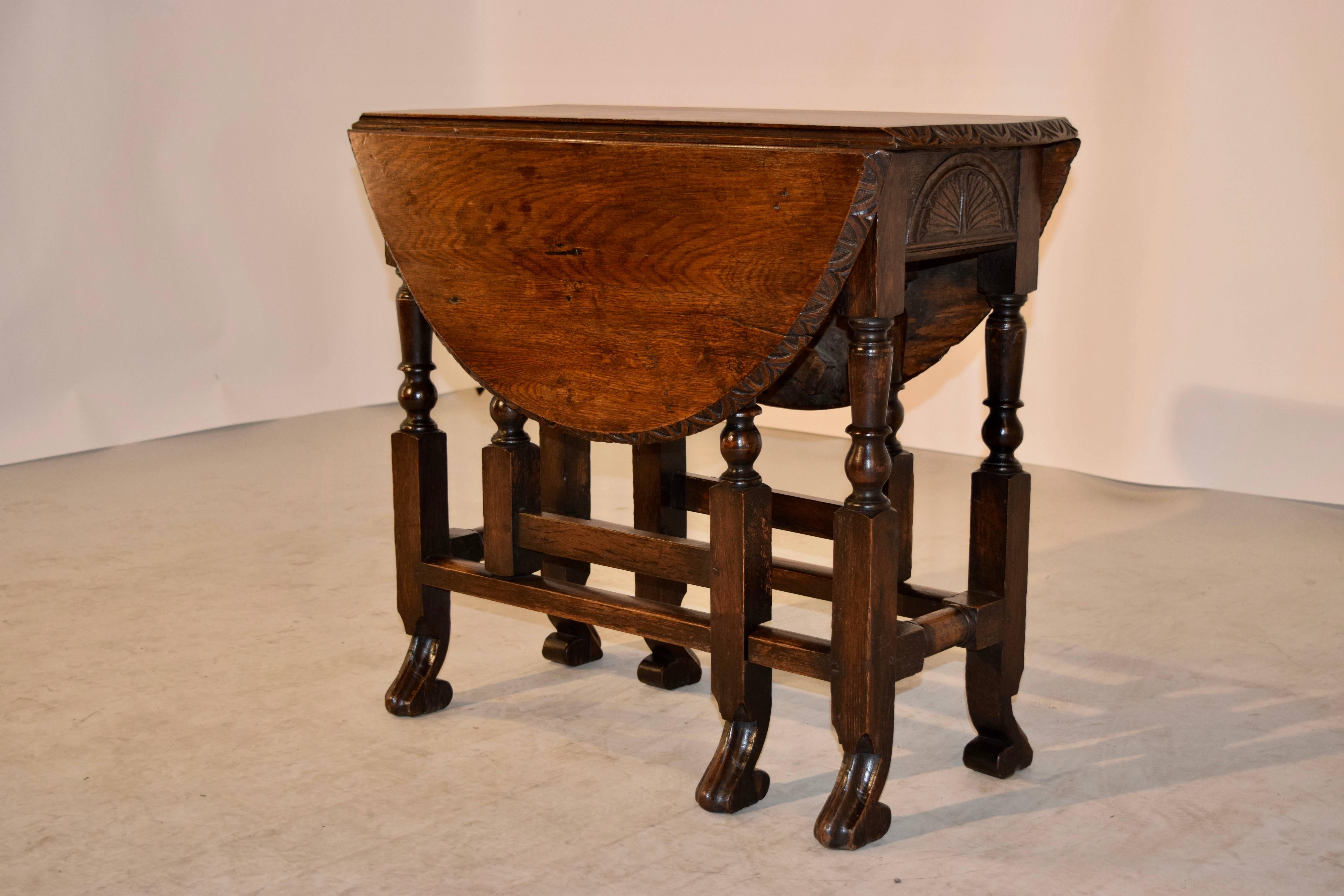 18th century English oak gateleg table with a lovely bevelled and gadrooned edge, following down to a carved apron on both ends of the table and supported on hand-turned legs, which ends in hand-carved scroll feet. The top open measures 30.75 x 36.5.