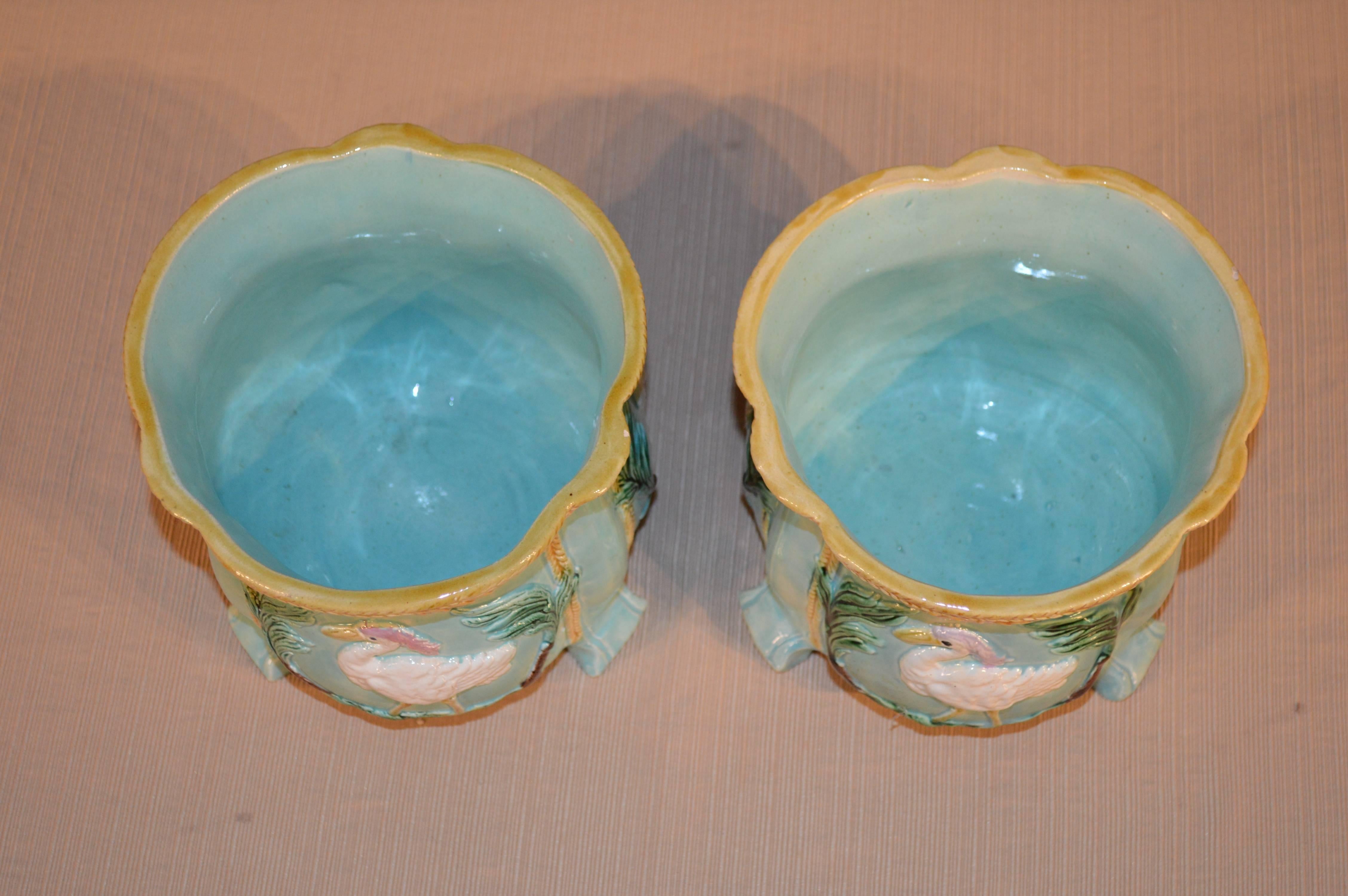 Pair of 19th century French Majolica planters in a gorgeous light turquoise color with birds in wreath garlands.