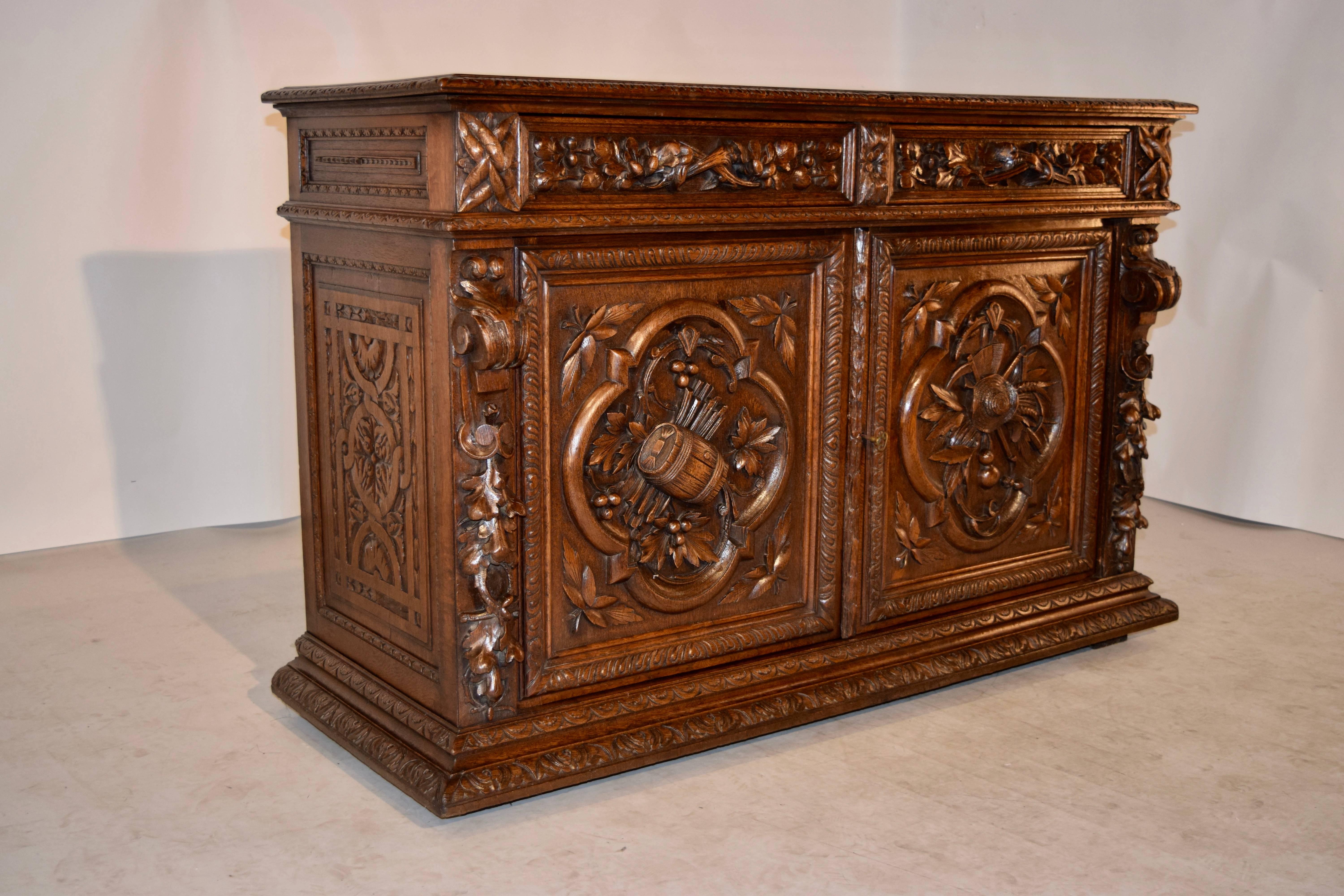 19th century carved French buffet made from oak. The top is banded and has a wonderfully bevelled edge with gadrooning, following down to panelled and carved sides on the sides, and heavily carved decorated drawer fronts and doors on the front. The