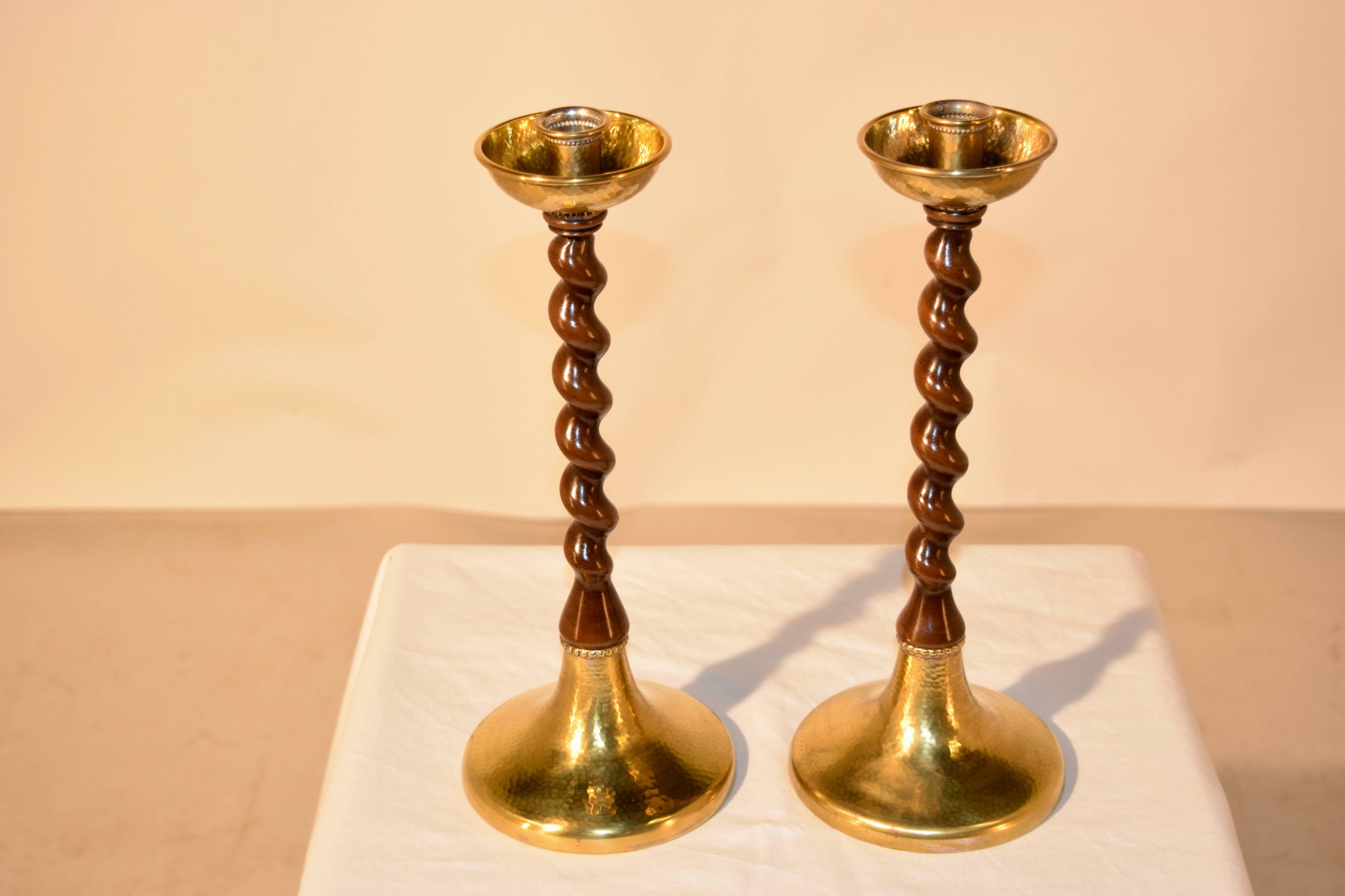 19th century pair of English candlesticks with hand-hammered brass candle cups and bases. The hand-turned barley twist stems are made from walnut.