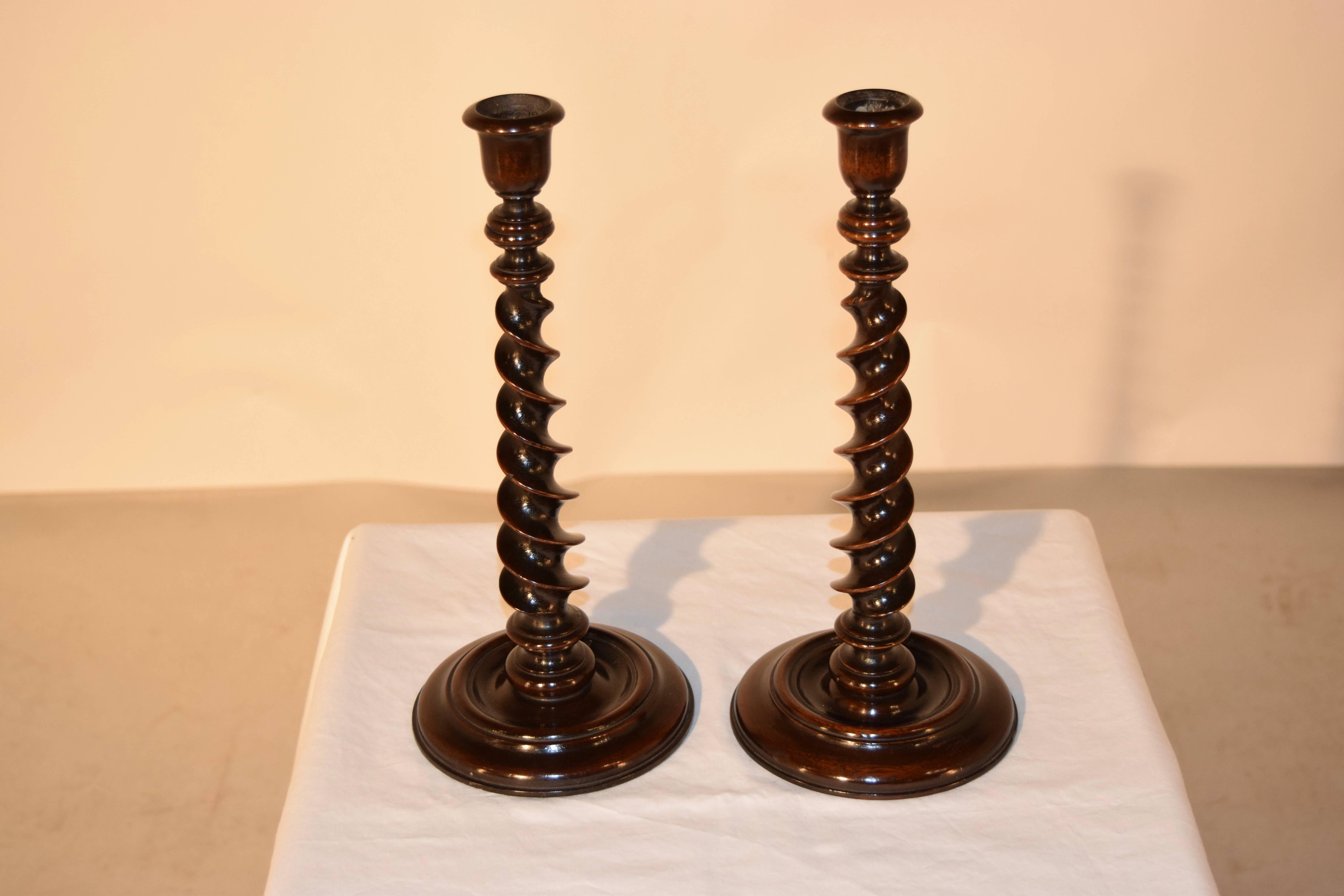 19th century pair of English candlesticks made from oak with wonderfully hand-turned ribbon barley twist stems and hand-turned candle cups, supported upon hand-turned bases.