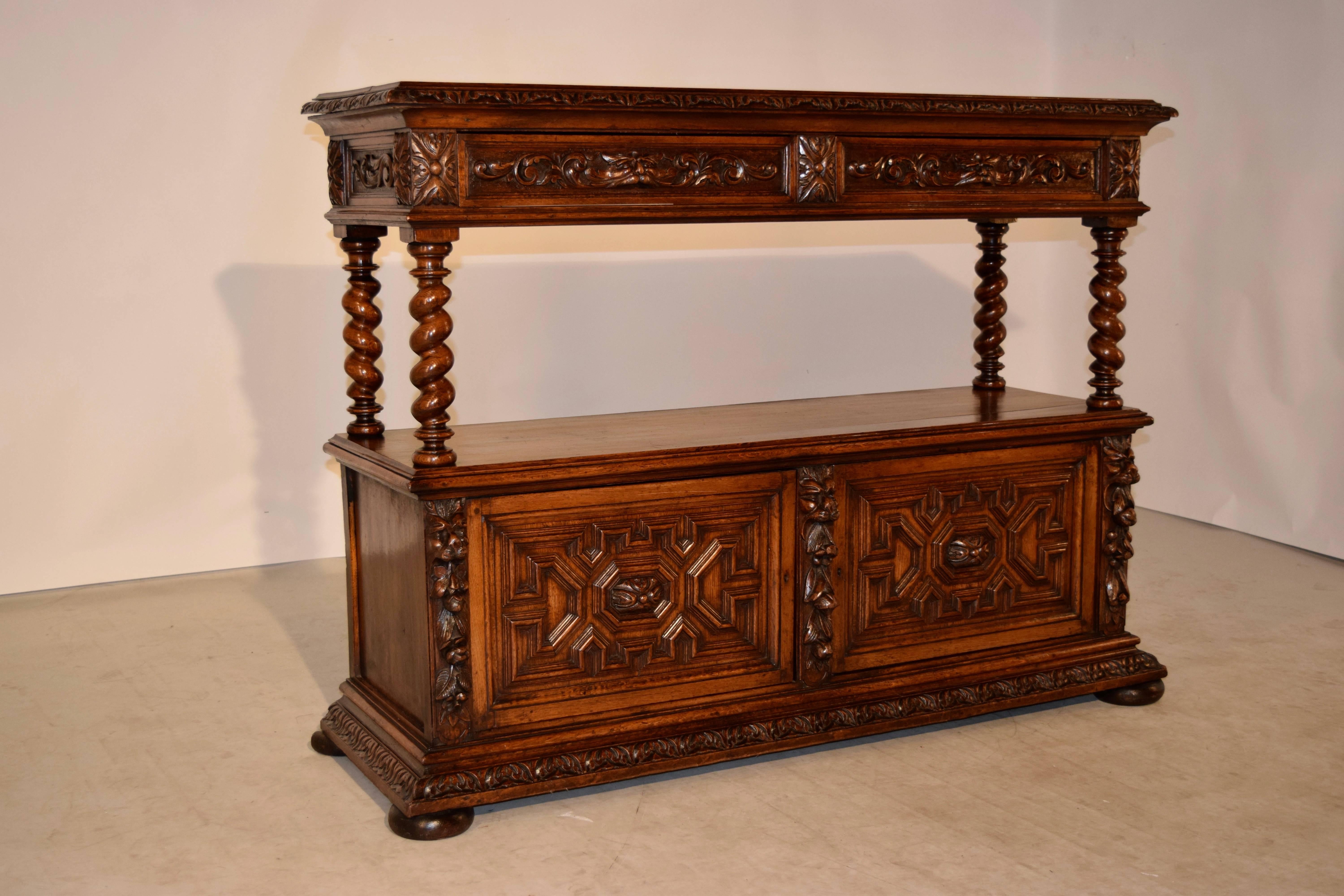 19th century oak buffet from France. The top has a bevelled and gadrooned edge and follows down to two drawers, which have lovely hand-carved decorated drawer fronts and pulls, and sides to match. The top is separated from the bottom of the case