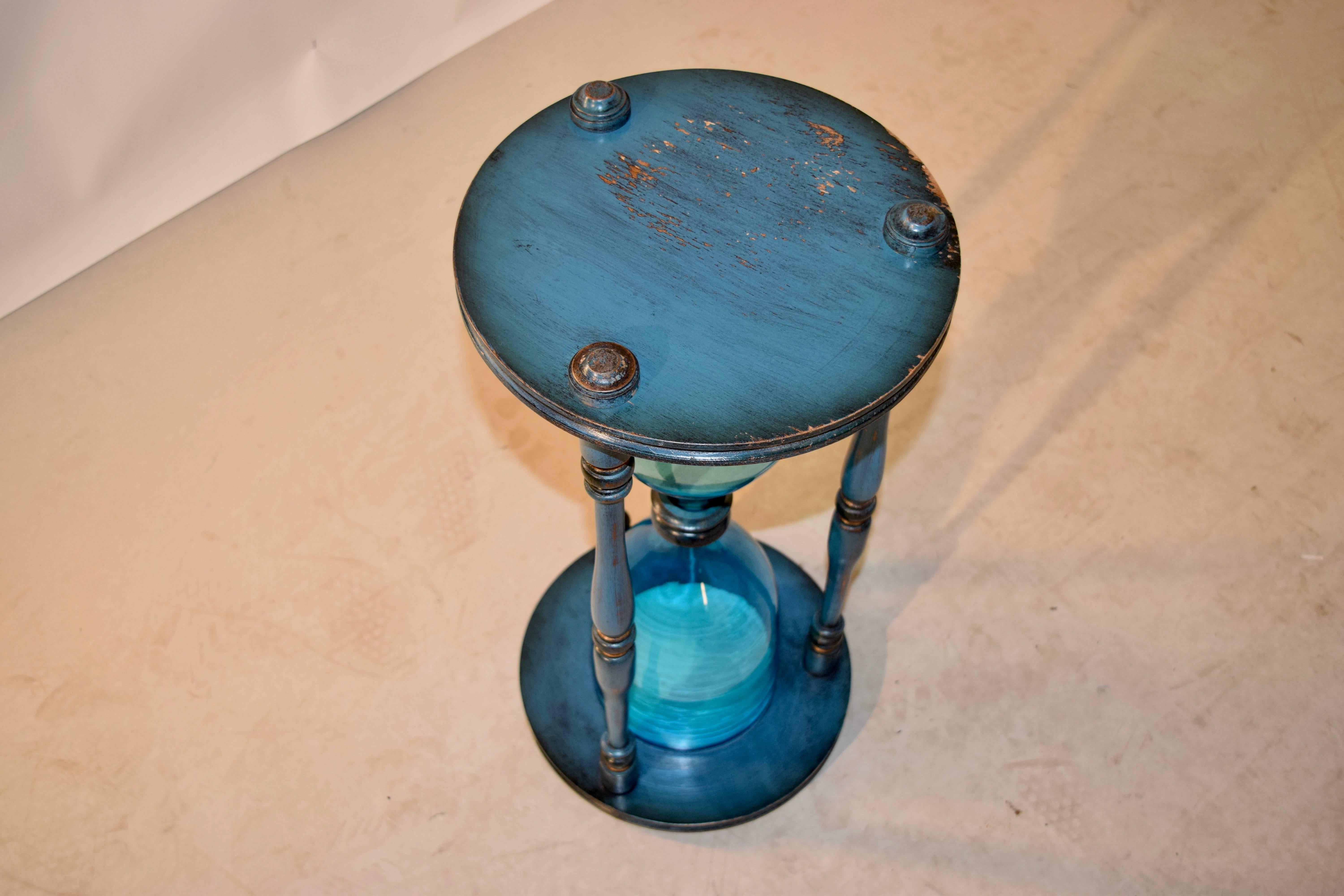 Large hourglass with handblown glass and wonderfully turned supports and bases, circa 1950s. The blue paint is original to the piece.