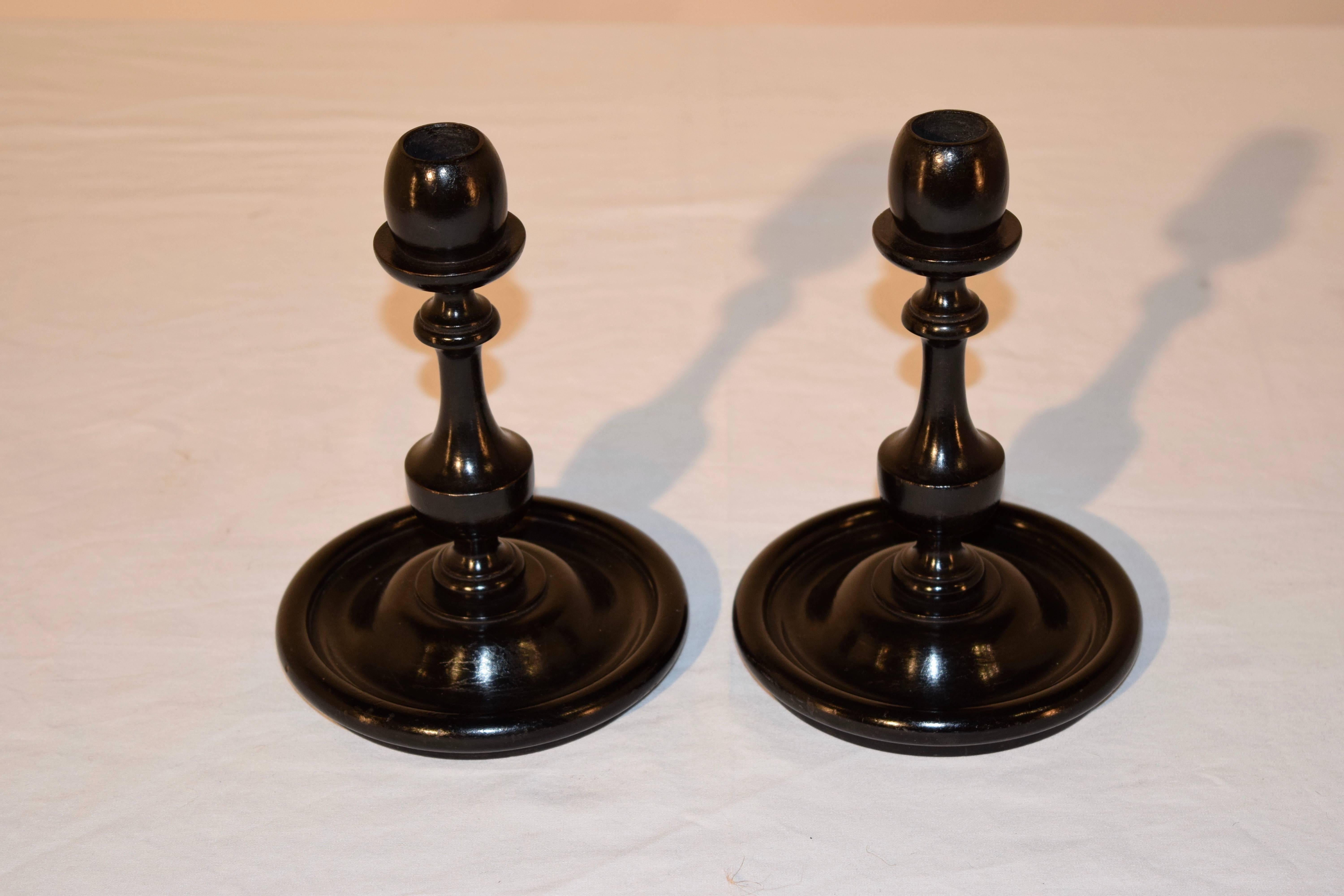 19th century pair of ebonized candlesticks with lovely turnings and supported on a turned dish base.