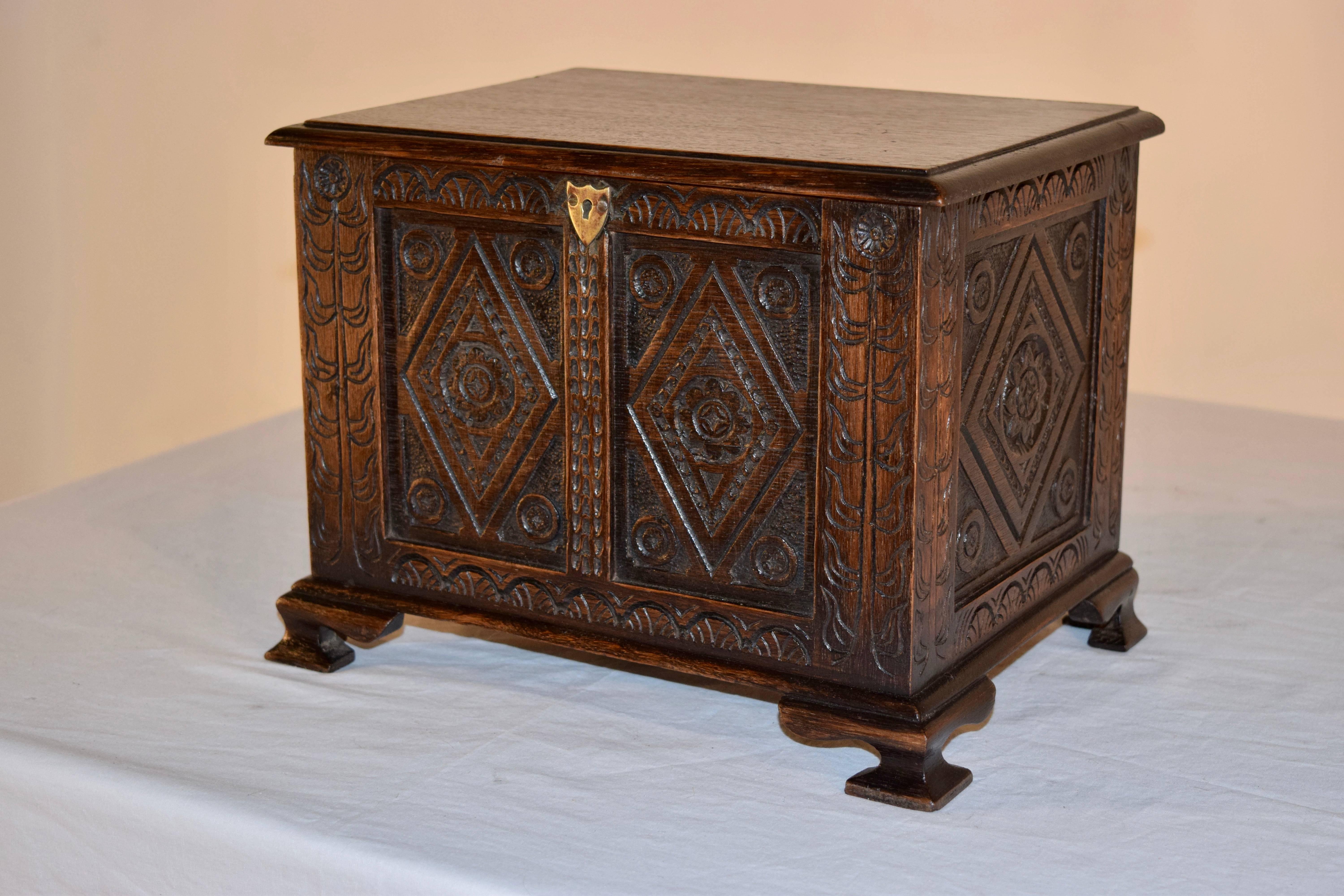 19th century carved miniature blanket chest with a beveled edge around the top, which is hinged in the back and lifts to reveal an open compartment. The sides and front are raised paneled and have wonderful hand-carved decorations. Raised on bracket