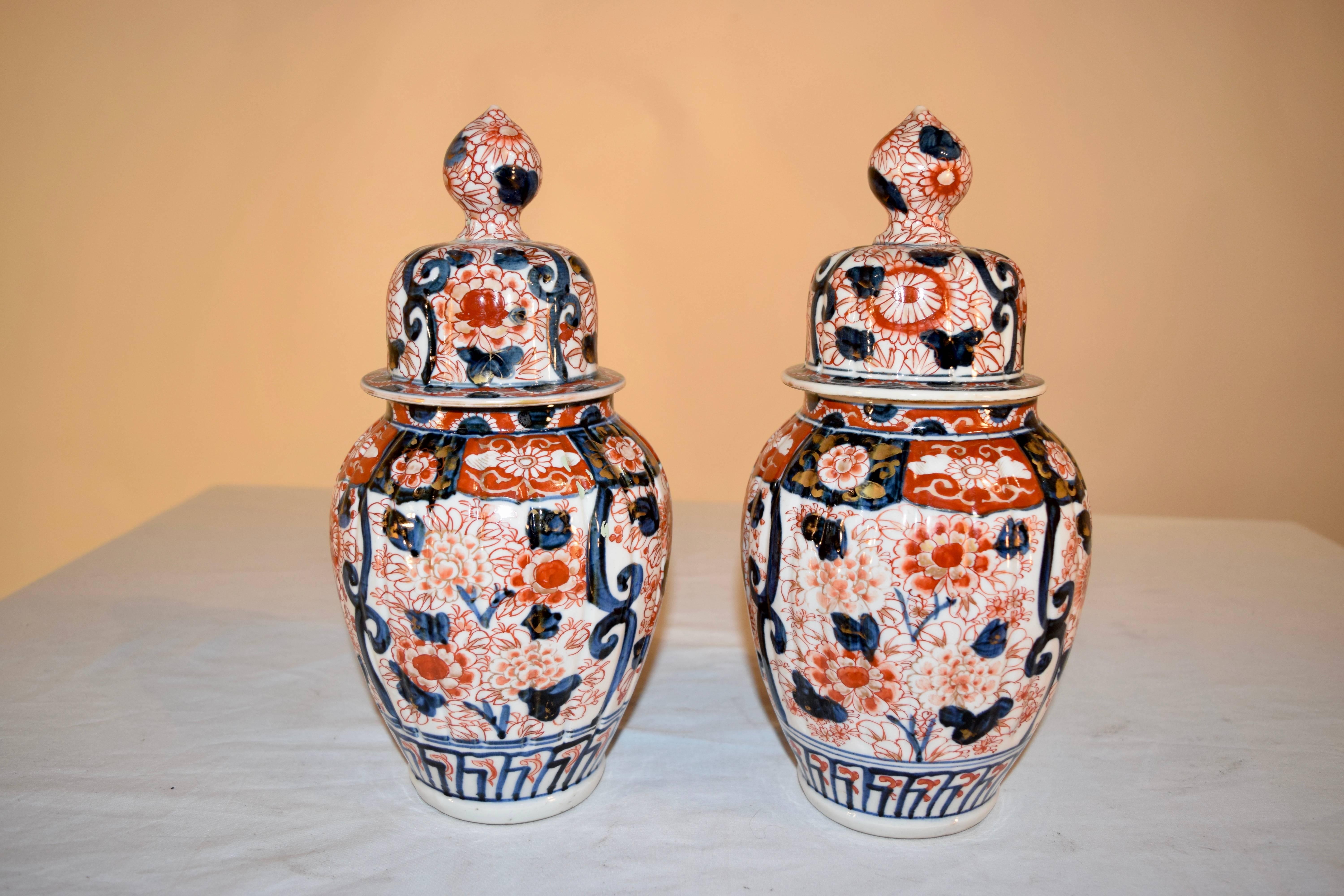 19th century pair of Imari lidded jars with lovely hand-painted designs in floral patterns of rust, cobalt, and gold.