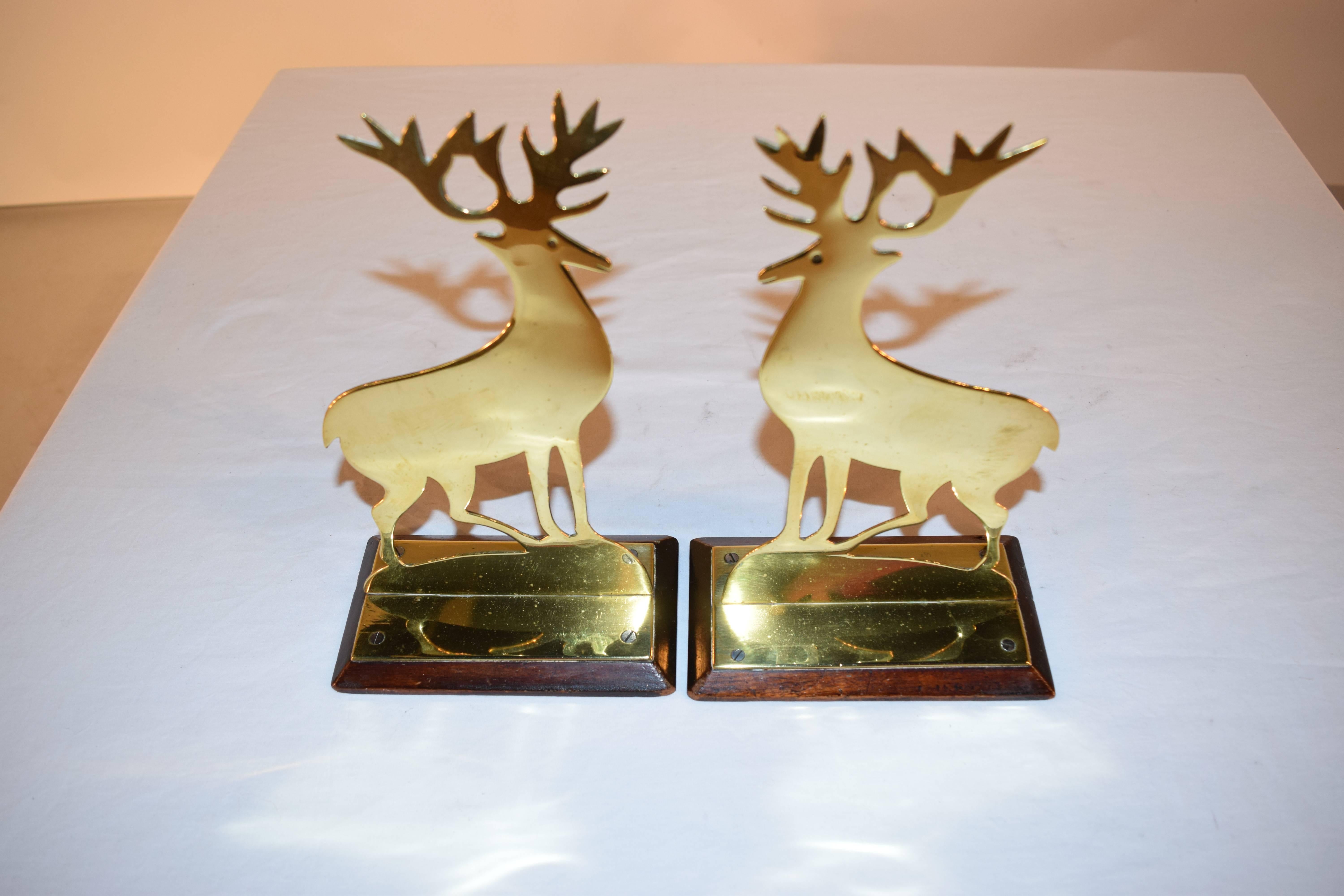 19th century pair of brass mantel decorations from England in the shape of stags on wooden bases.