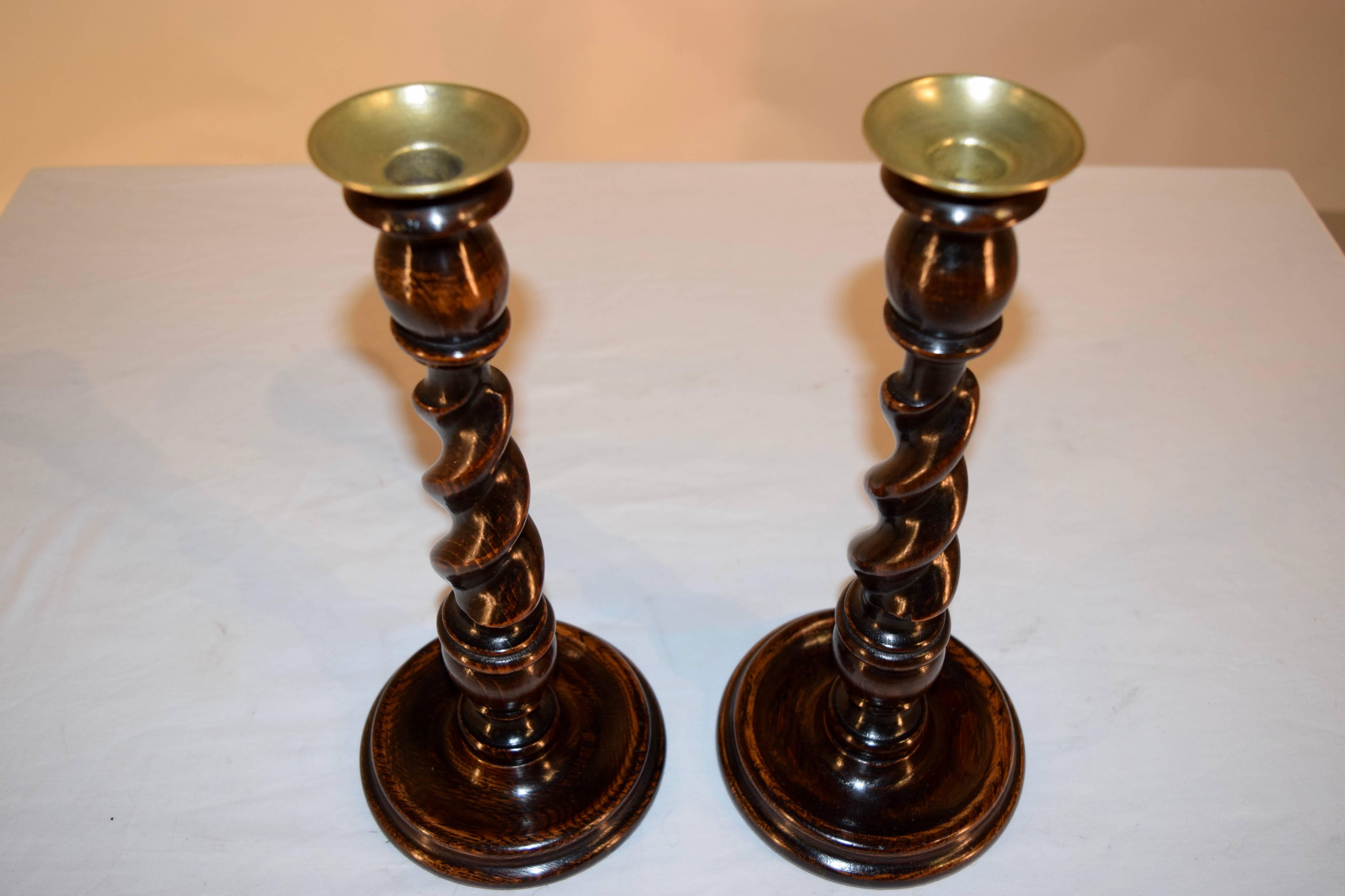 Pair of 19th century English oak hand-turned candlesticks with tulip shaped candle cups, barley twist stems and hand-turned dish shaped bases. They have newly hand-turned brass bobeches.