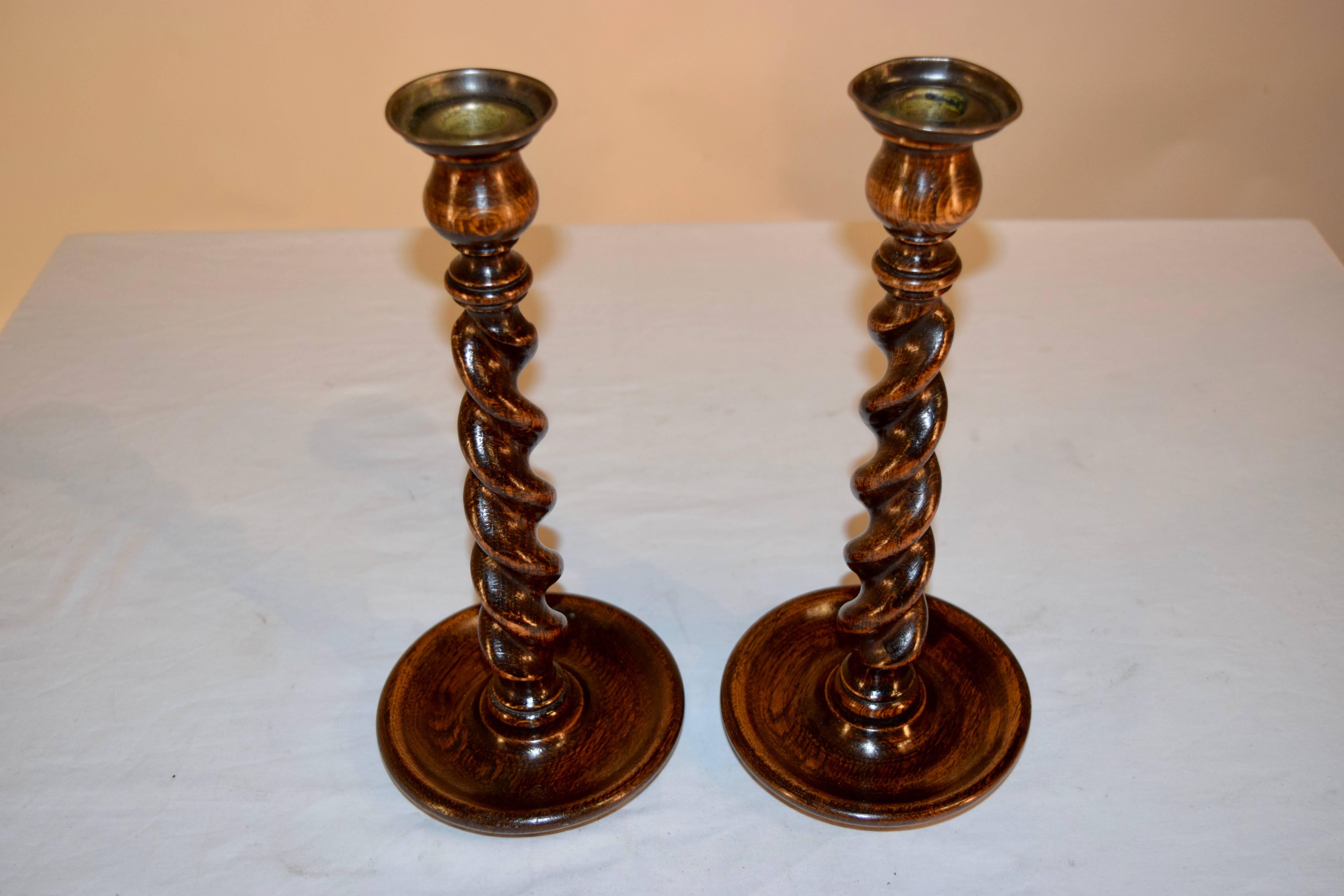 19th century pair of hand-turned candlesticks with original brass bobeches, following down to hand-turned tulip shaped candle cups, over a hand-turned neck and barley twist stems. Supported on hand-turned dish bases.