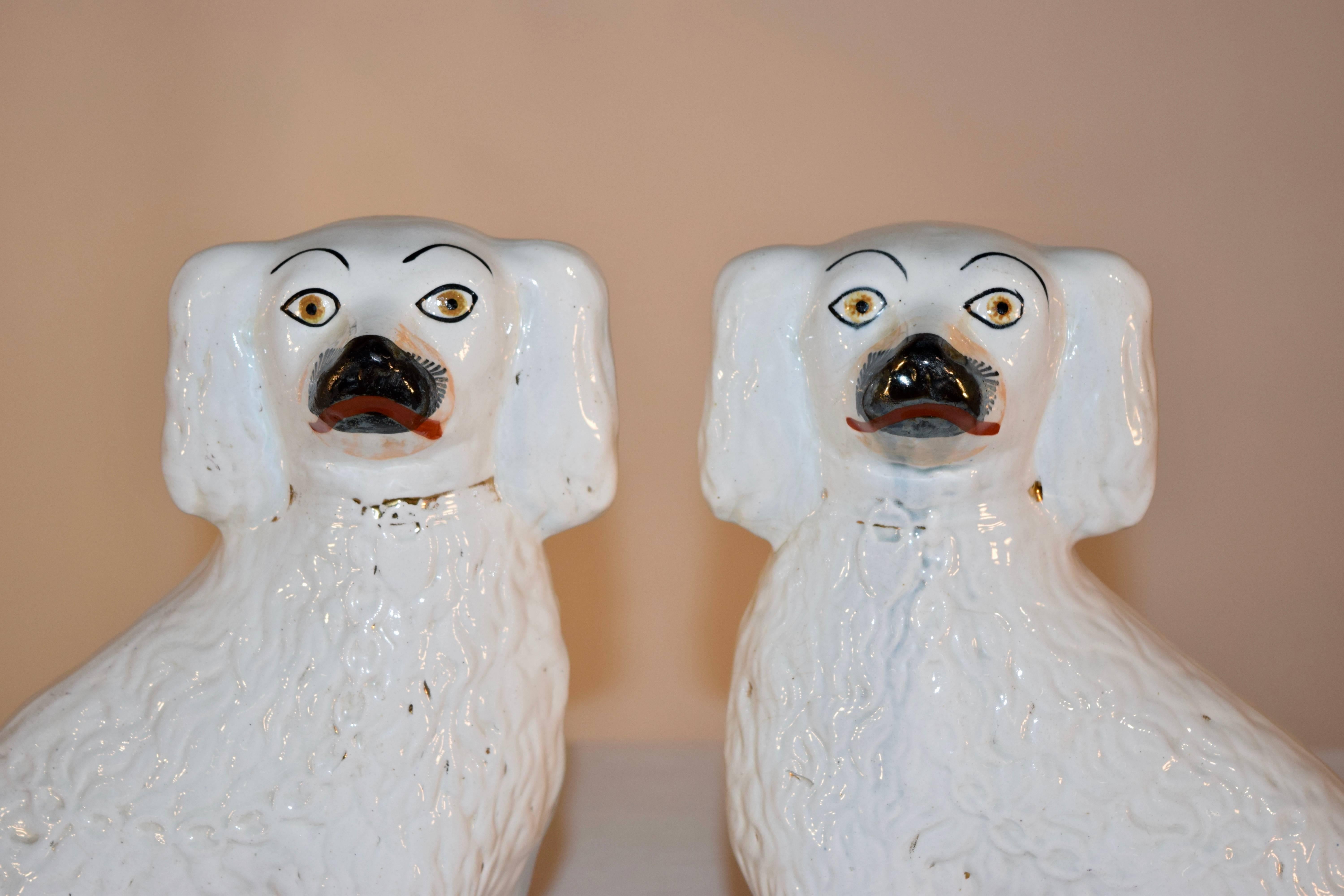 Pair of 19th century Staffordshire spaniels from England with remnants of gold decoration and great curly tails. General wear for age.