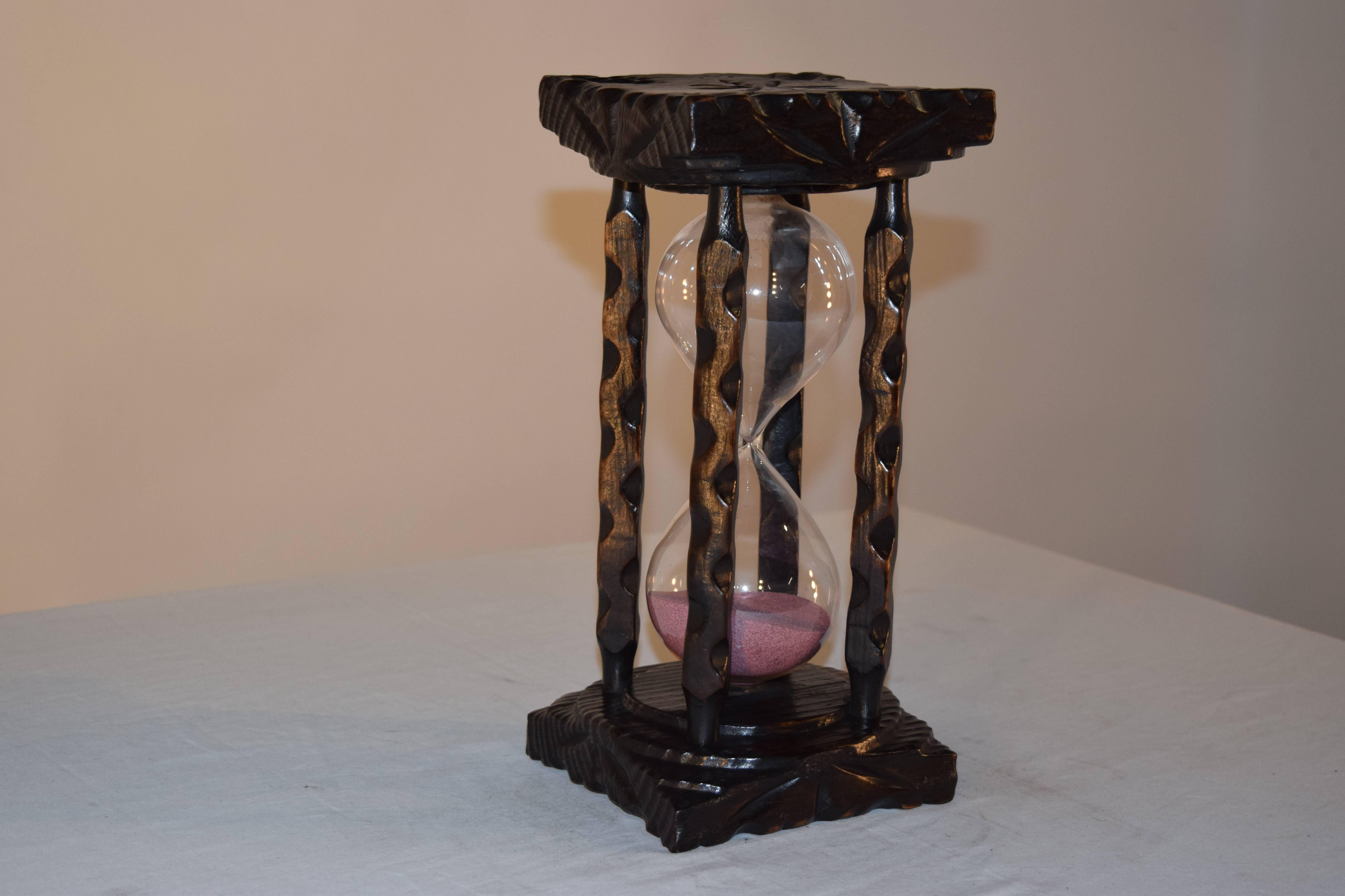 19th century hand-carved hourglass from England. The top and bottom are hand-carved and are joined by hand-carved spindles. The glass is handblown and is filled with sand.