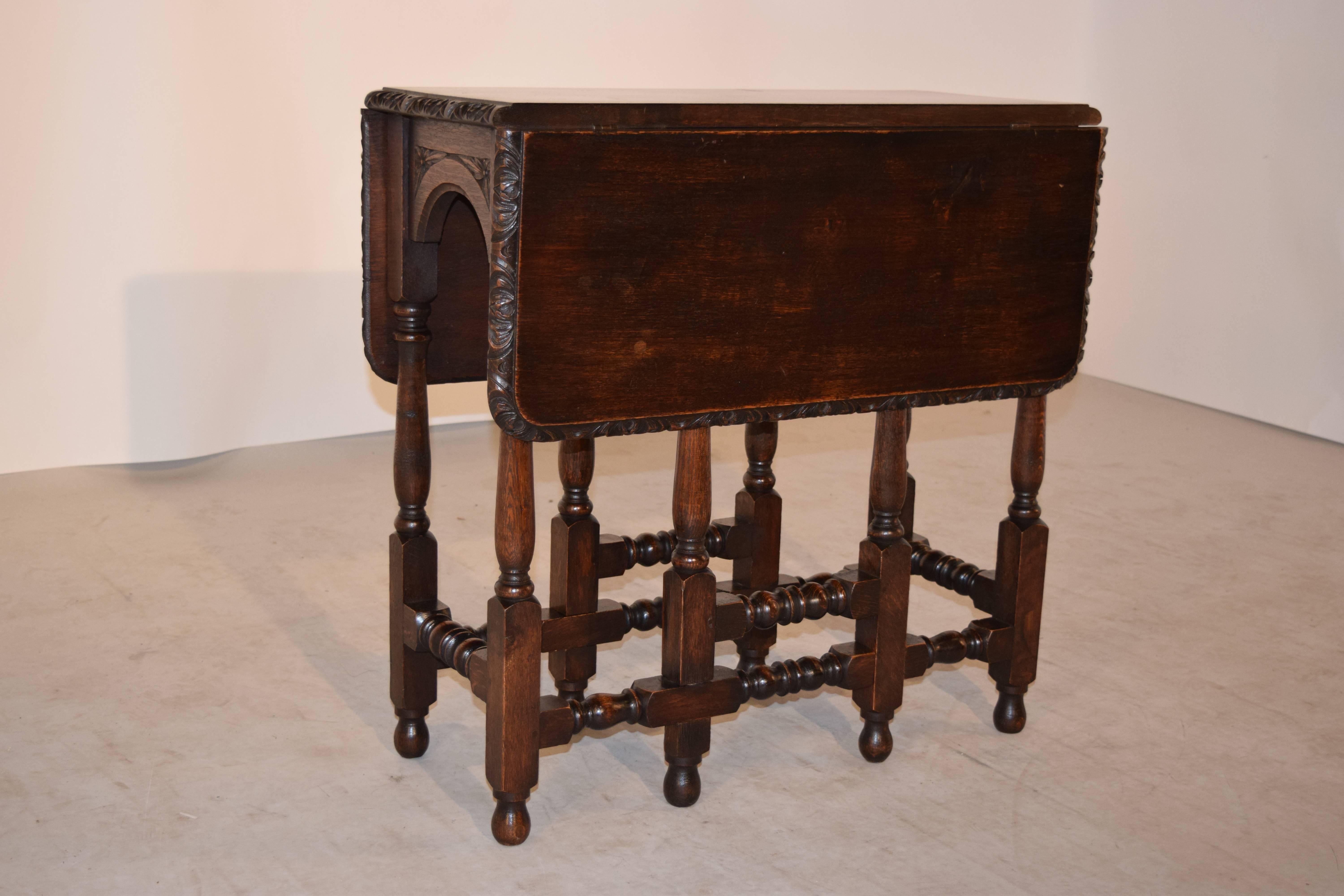 19th century English oak gate leg table with a rectangular shaped top. The top has a wonderfully hand-carved decorated edge, following down to arched and carved decorated aprons on the ends, and supported on hand-turned legs and feet. The top open