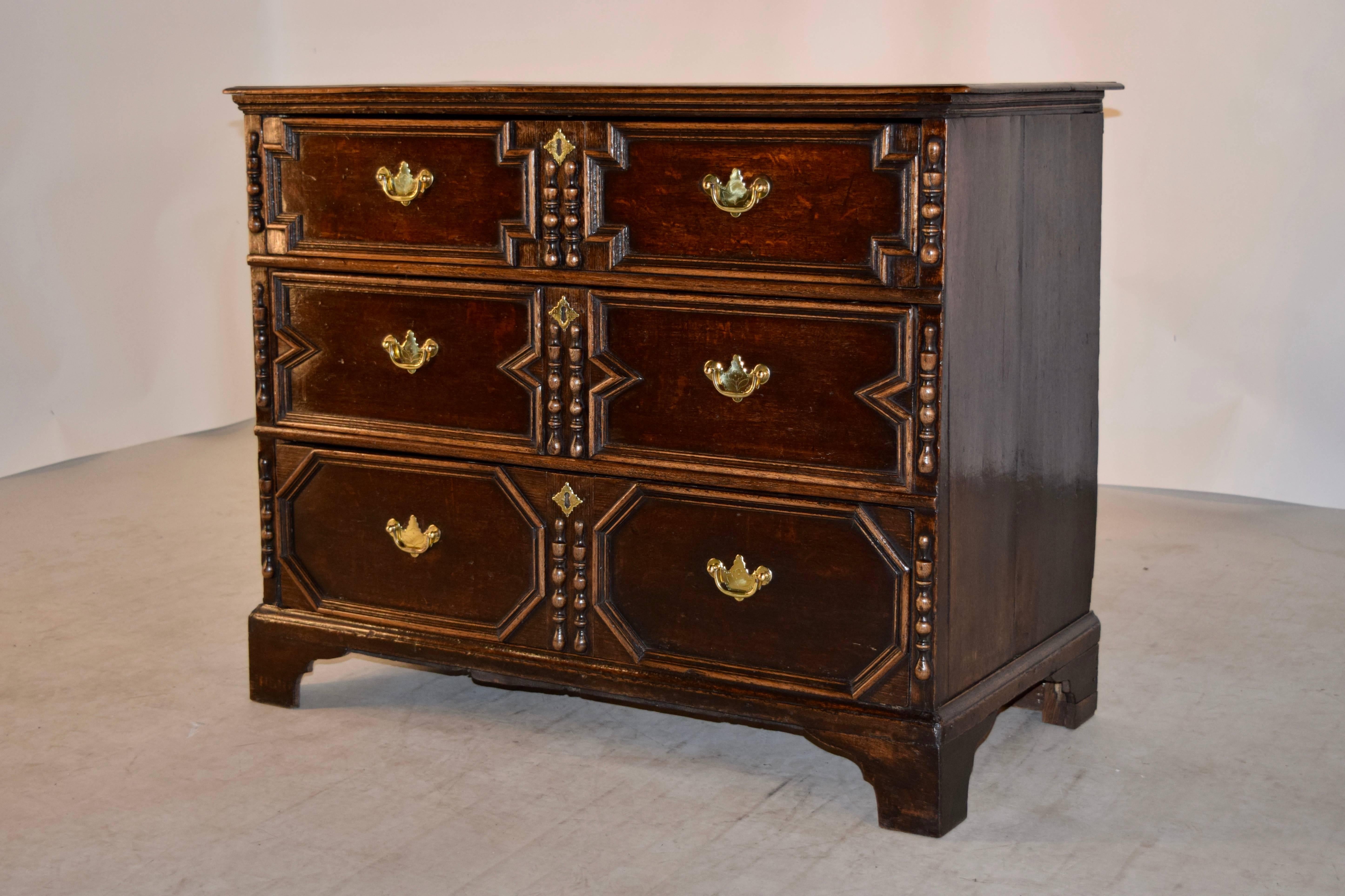 English oak chest of drawers with a two plank top which has a beveled edge, following down to a simple case with two plank sides and three drawers in the front, circa 1720. The drawers have applied molding in geometric patterns and split molded