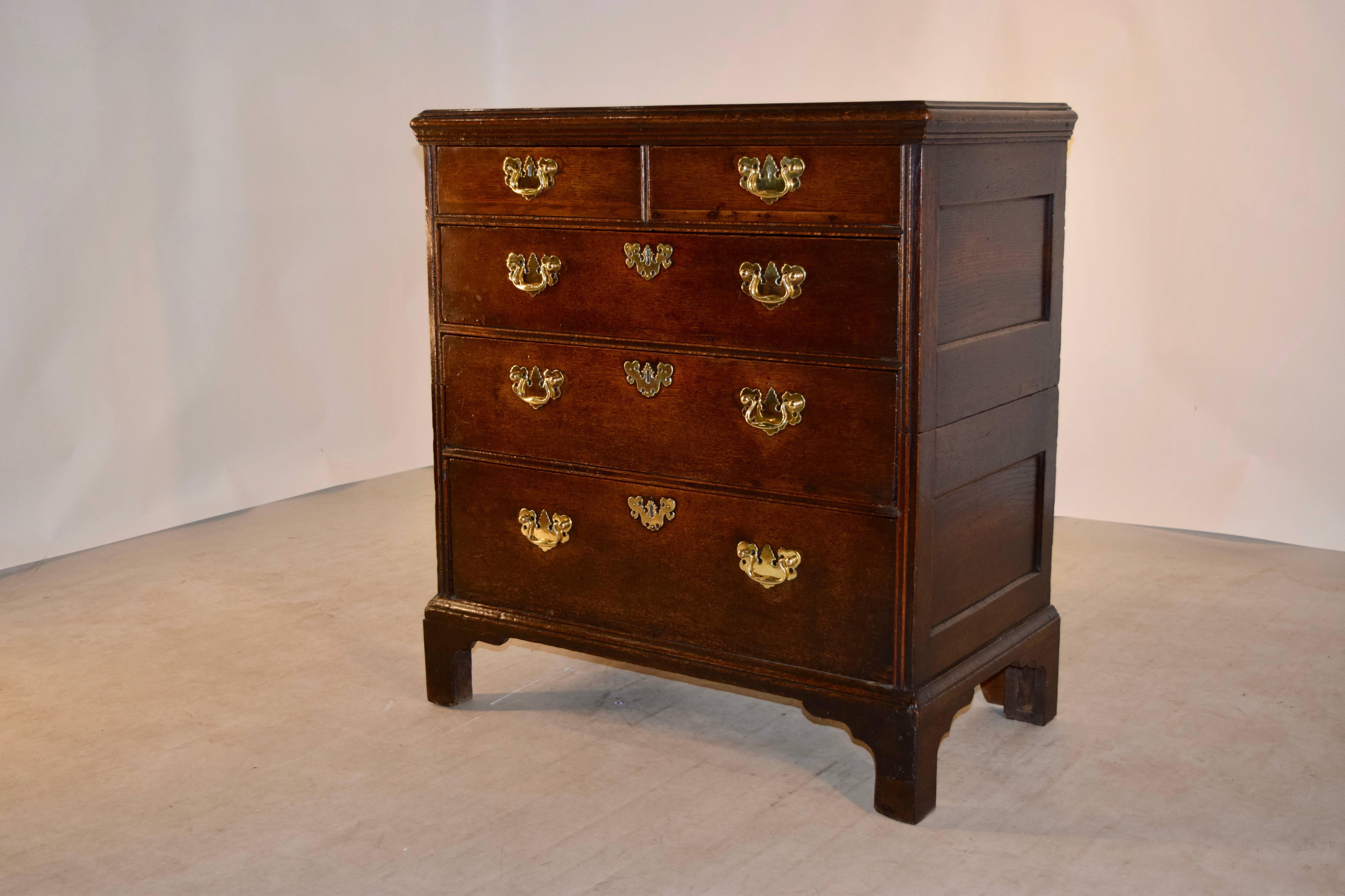 Early 19th century oak chest of drawers from England with a beveled top around the edge, following down to two drawers over three drawers in the front, and hand paneled sides. It is raised on bracket feet. The drawers have old repairs, and the top