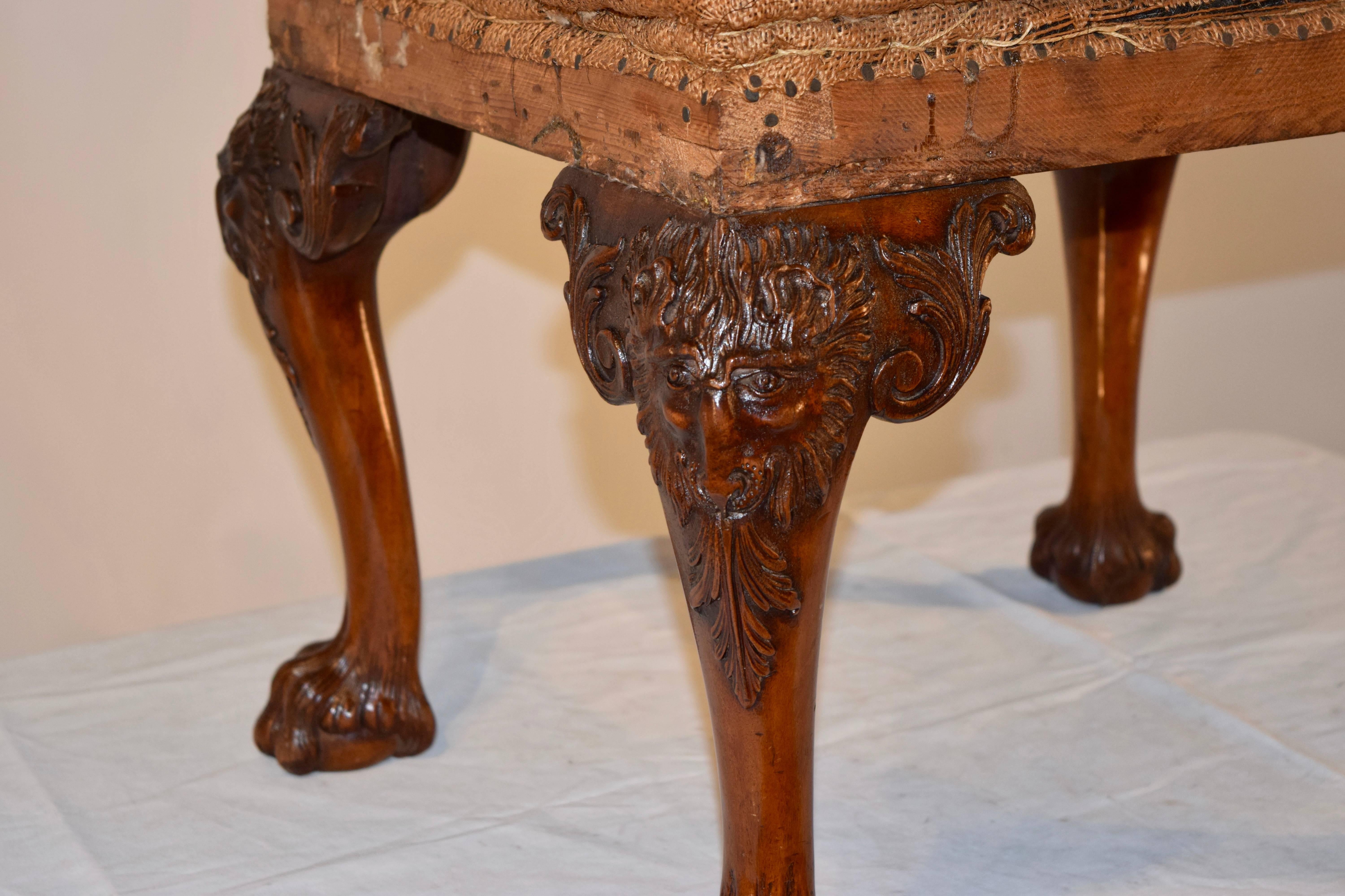 18th century mahogany stool in original condition with horse hair and burlap upholstery with webbing underneath. The frame has wonderfully cabriole legs with hand-carved rams and foliage, ending in hairy paw feet.