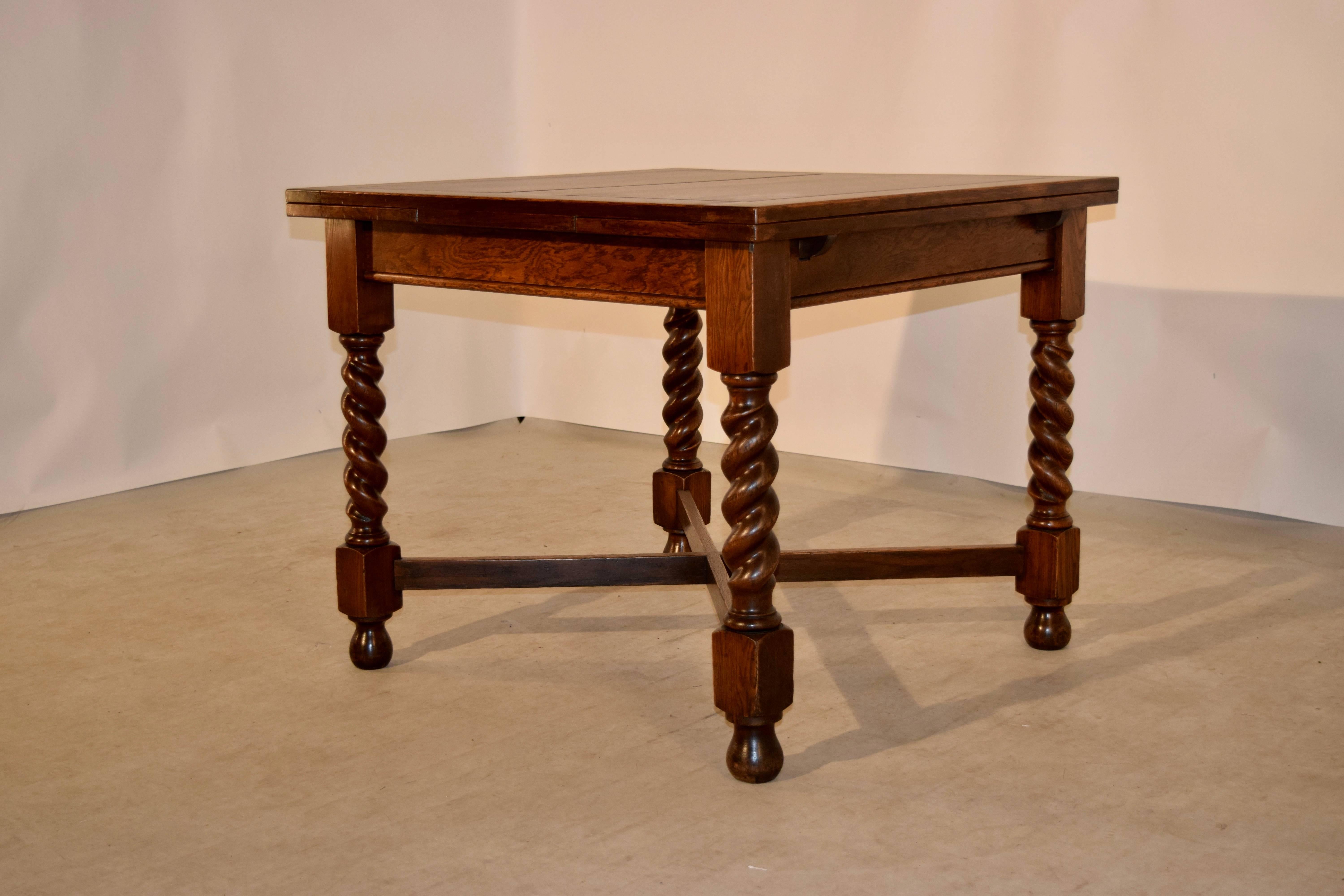 English oak draw-leaf table with panelled top and leaves, following down to a simple apron, and supported on hand turned barley twist legs, which are joined by cross stretchers and supported on turned feet, circa 1900. The top open measures 59.63 x
